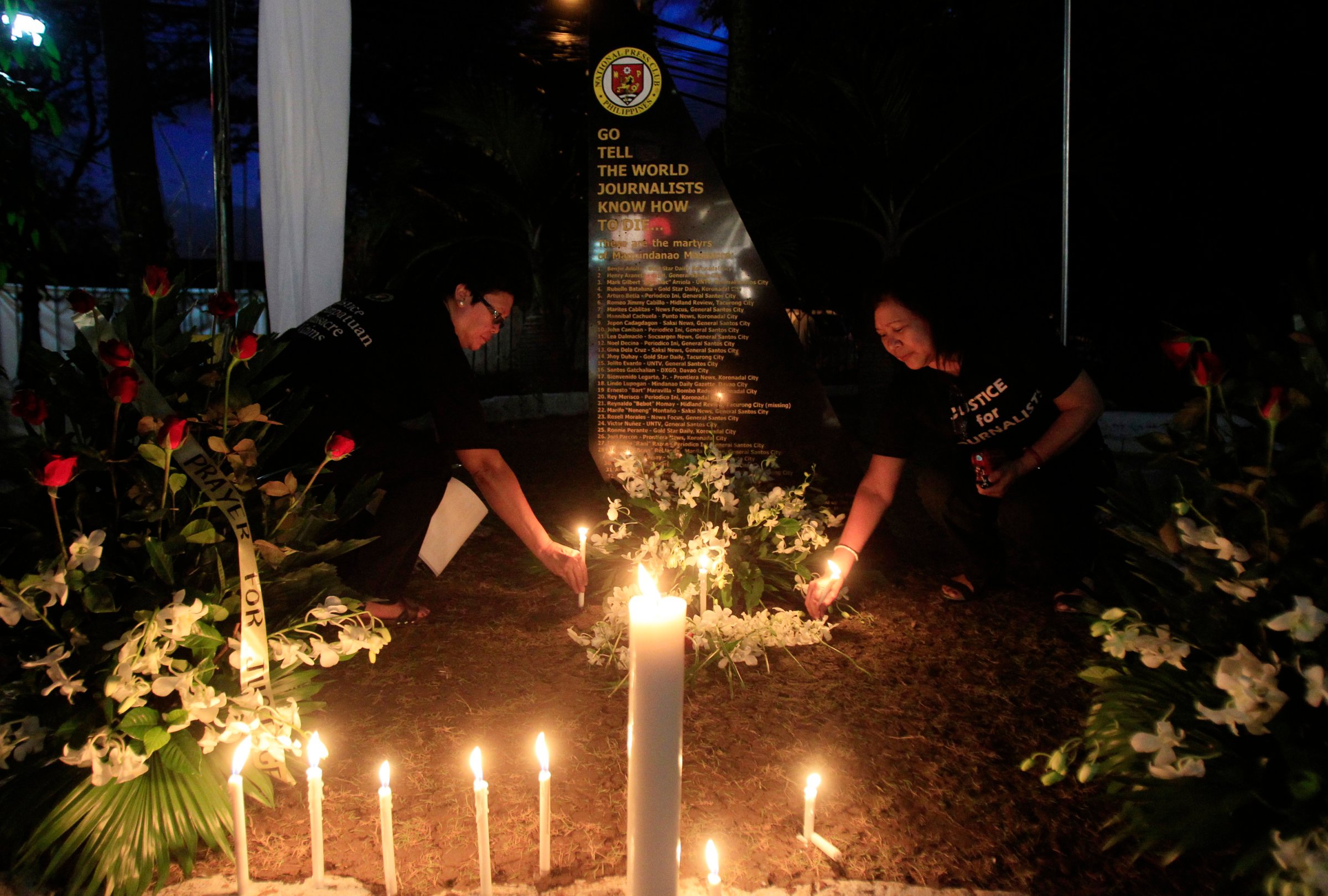 Filipino journalists light candles to commemorate the 2nd year anniversary of the "Maguindanao Massacre" at the National Press Club compound in Manila