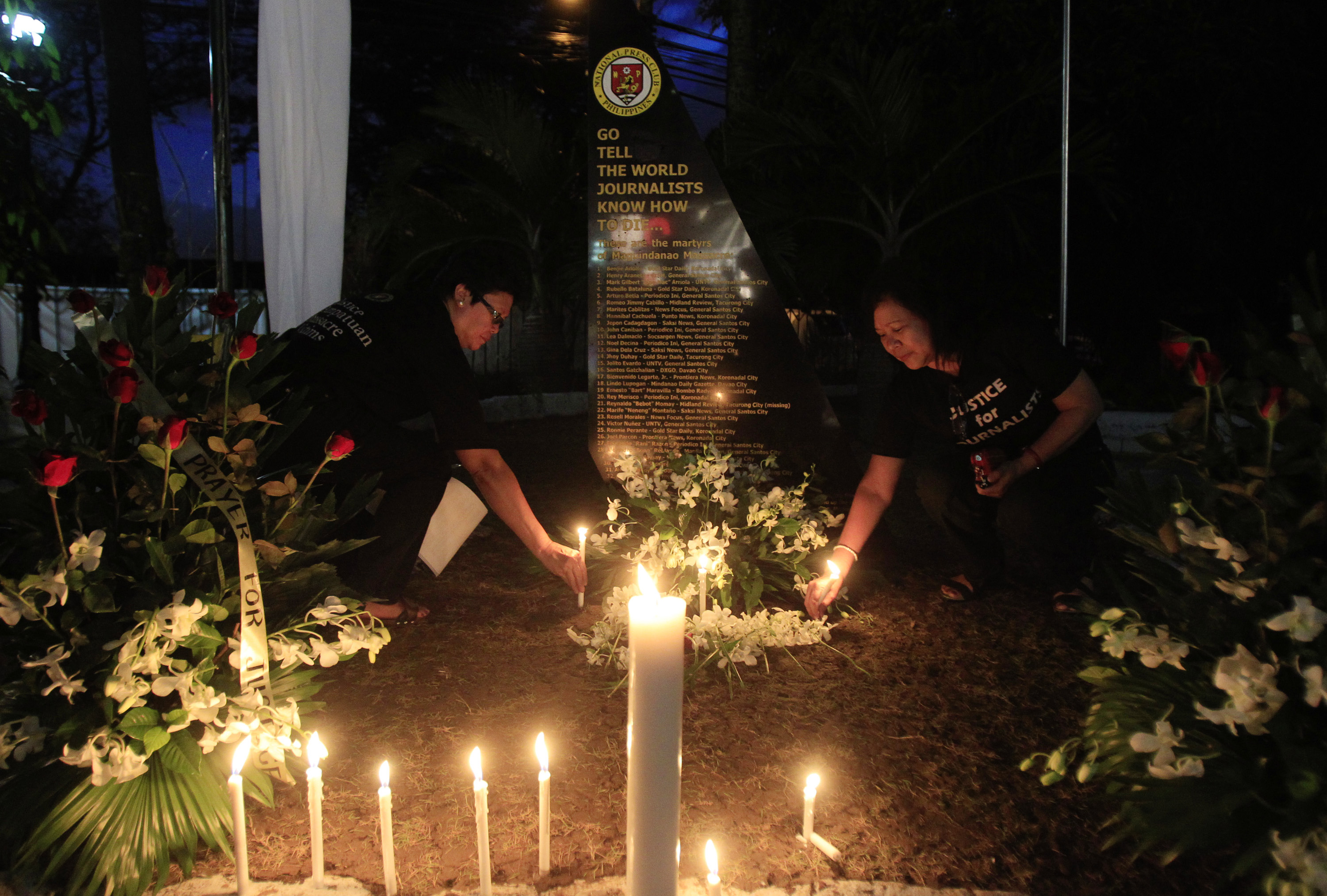 Filipino journalists light candles to commemorate the second-year anniversary of the Maguindanao massacre at the National Press Club compound in Manila on Nov. 23, 2011 (Erik de Castro—Reuters)