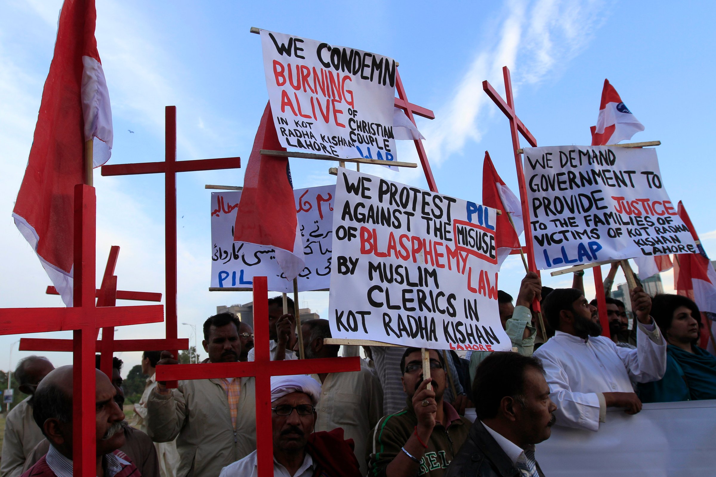 Members of the Pakistani Christian community hold placards and wooden crosses during a demonstration to condemn the death of a Christian couple in a village in Punjab province on Tuesday, in Islamabad