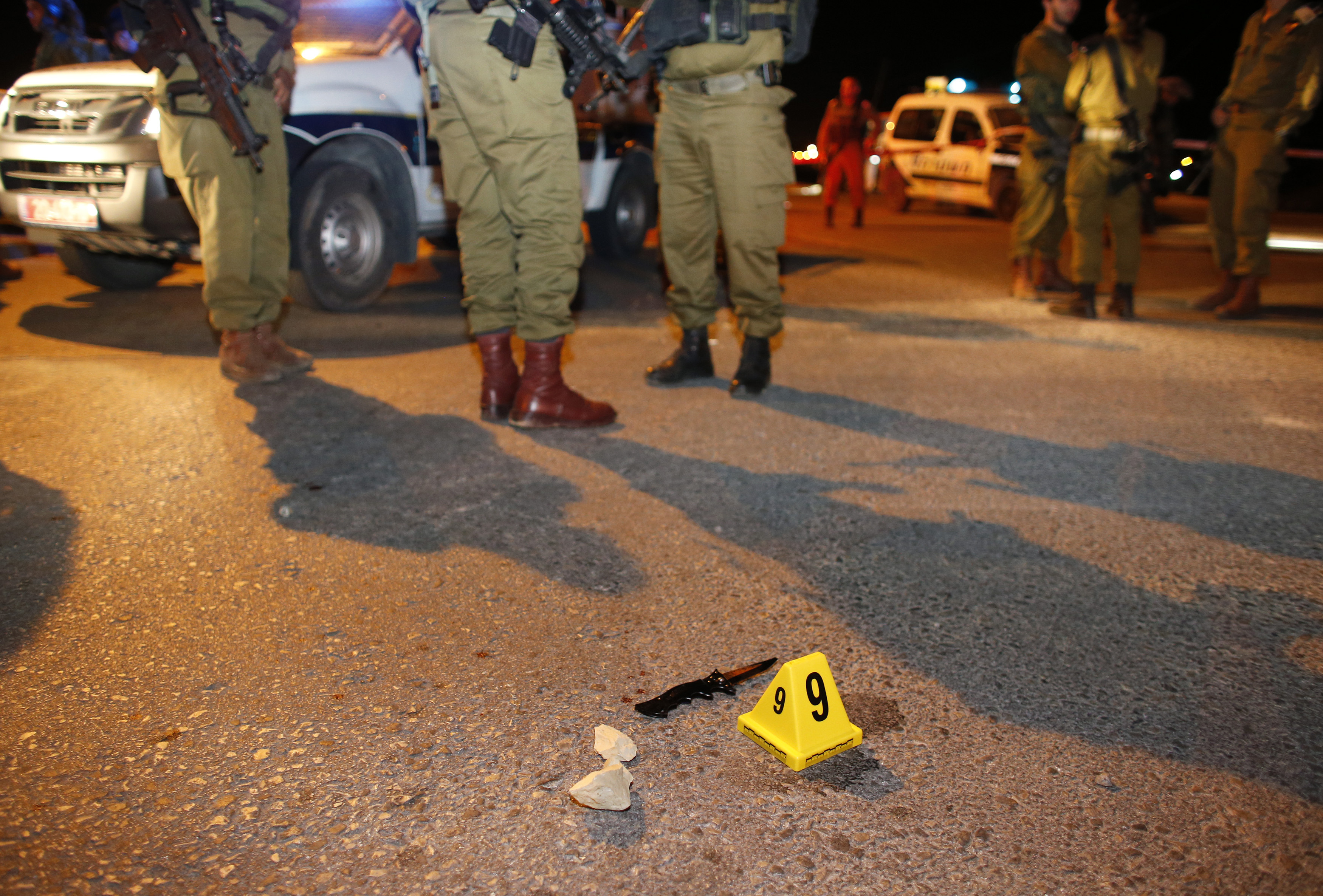 Israeli soldiers stand near a knife at the scene of a stabbing attack near the West Bank Jewish settlement of Alon Shvut