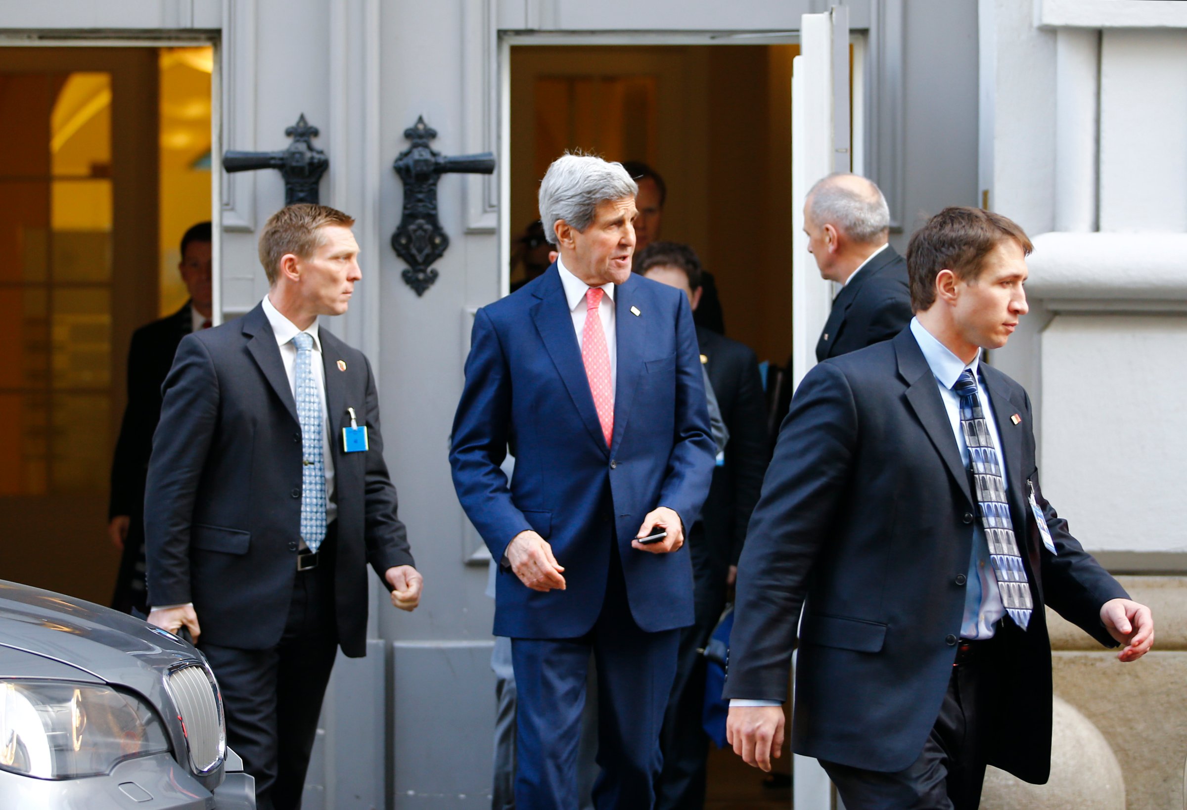 U.S. Secretary of State Kerry is surrounded by security as he leaves after a meeting in Vienna