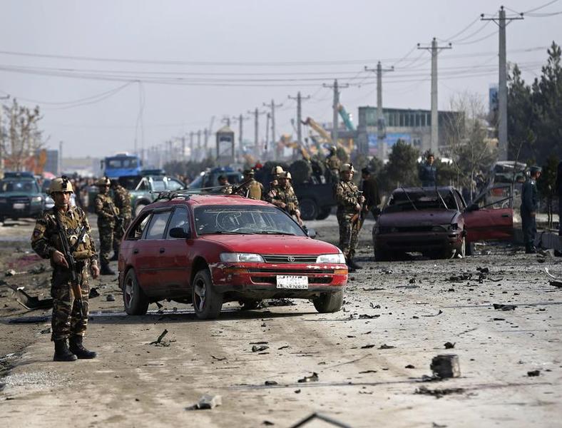Afghan security forces inspect the site of a suicide attack on a British embassy vehicle in Kabul
