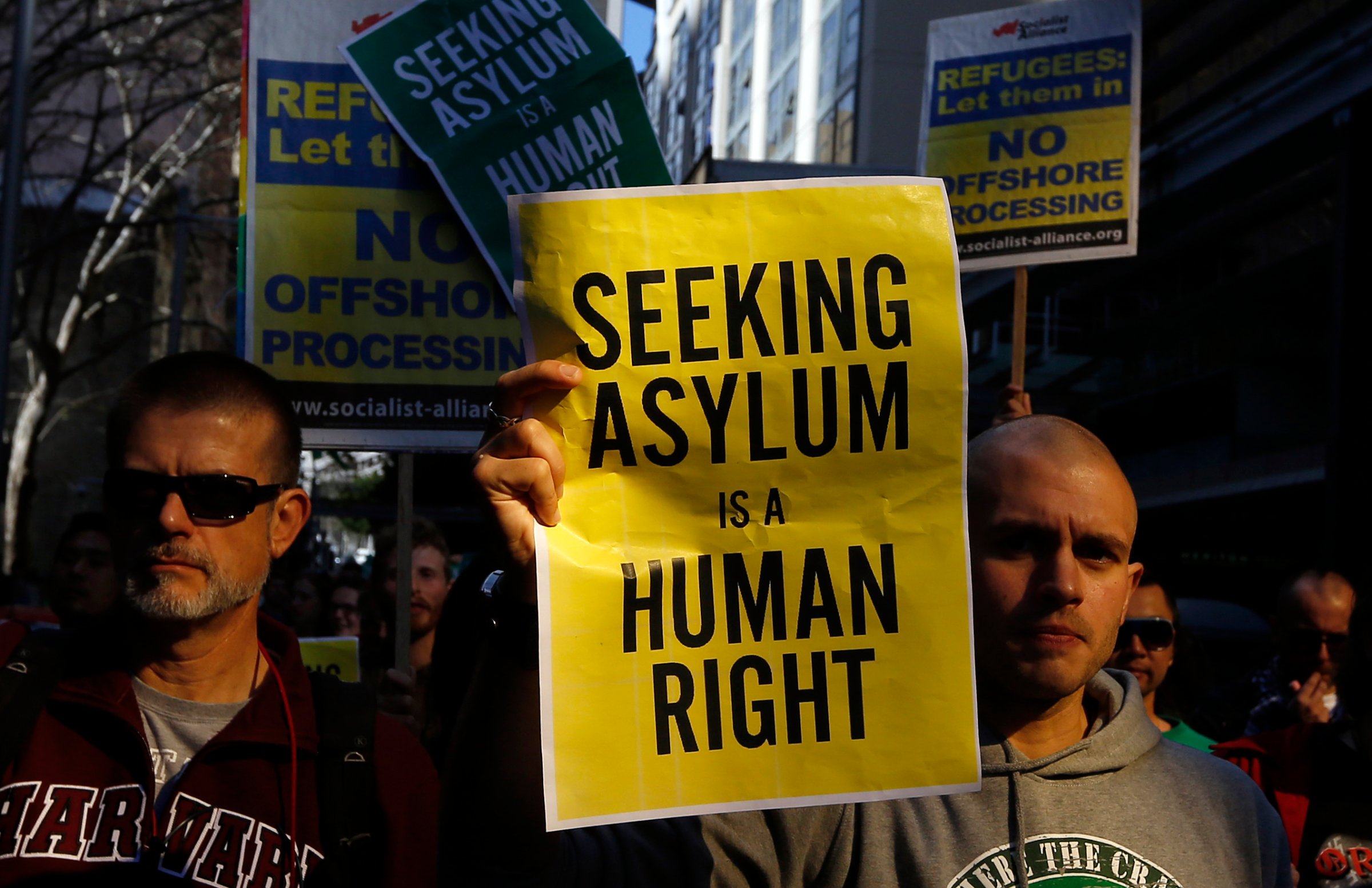 Man holds a poster during a rally in support of asylum seekers in central Sydney