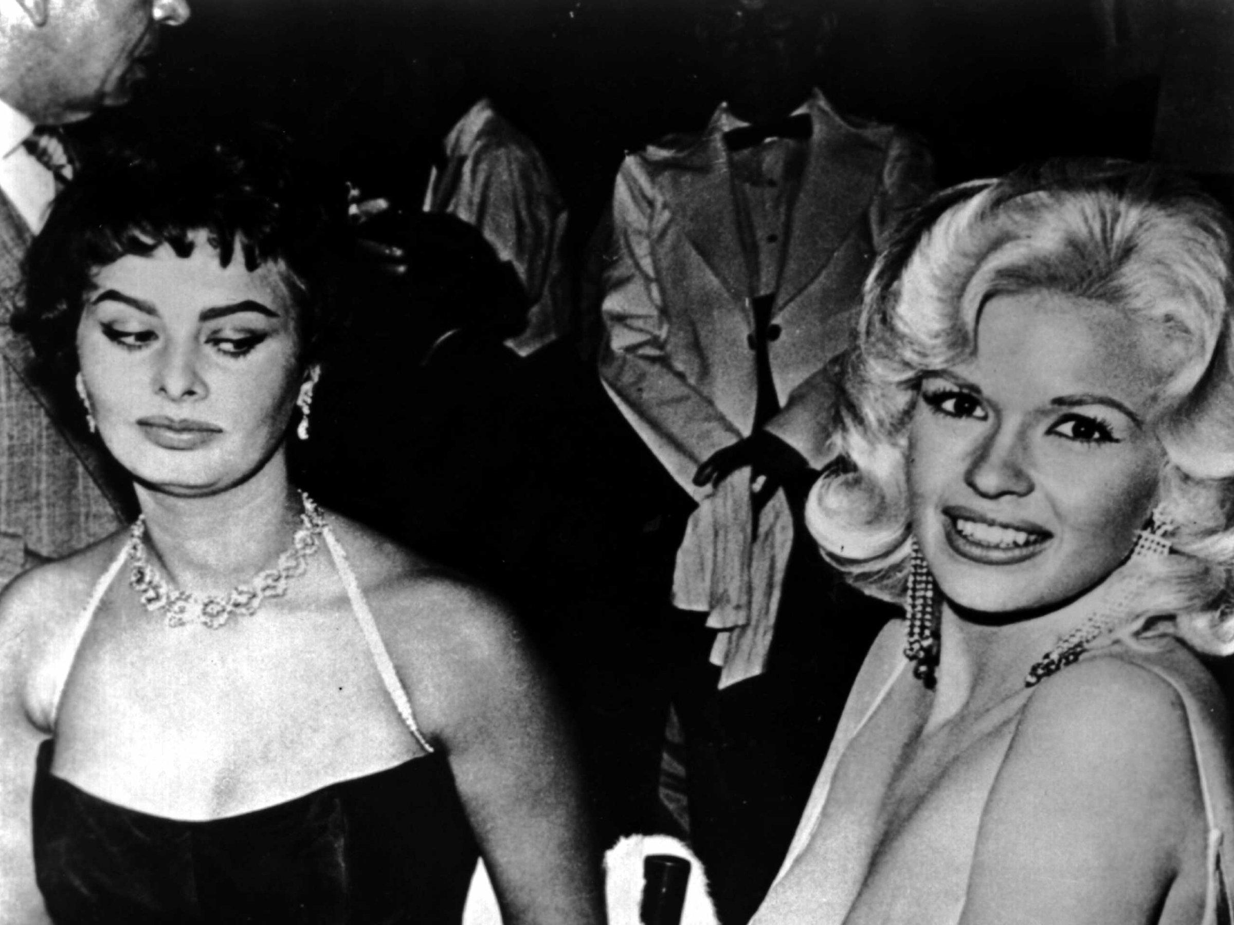 Jayne Mansfield tries to steal the show in a very low cut dress at a party thrown by 20th Century-Fox for Sophia Loren on April 12, 1957 in Los Angeles.