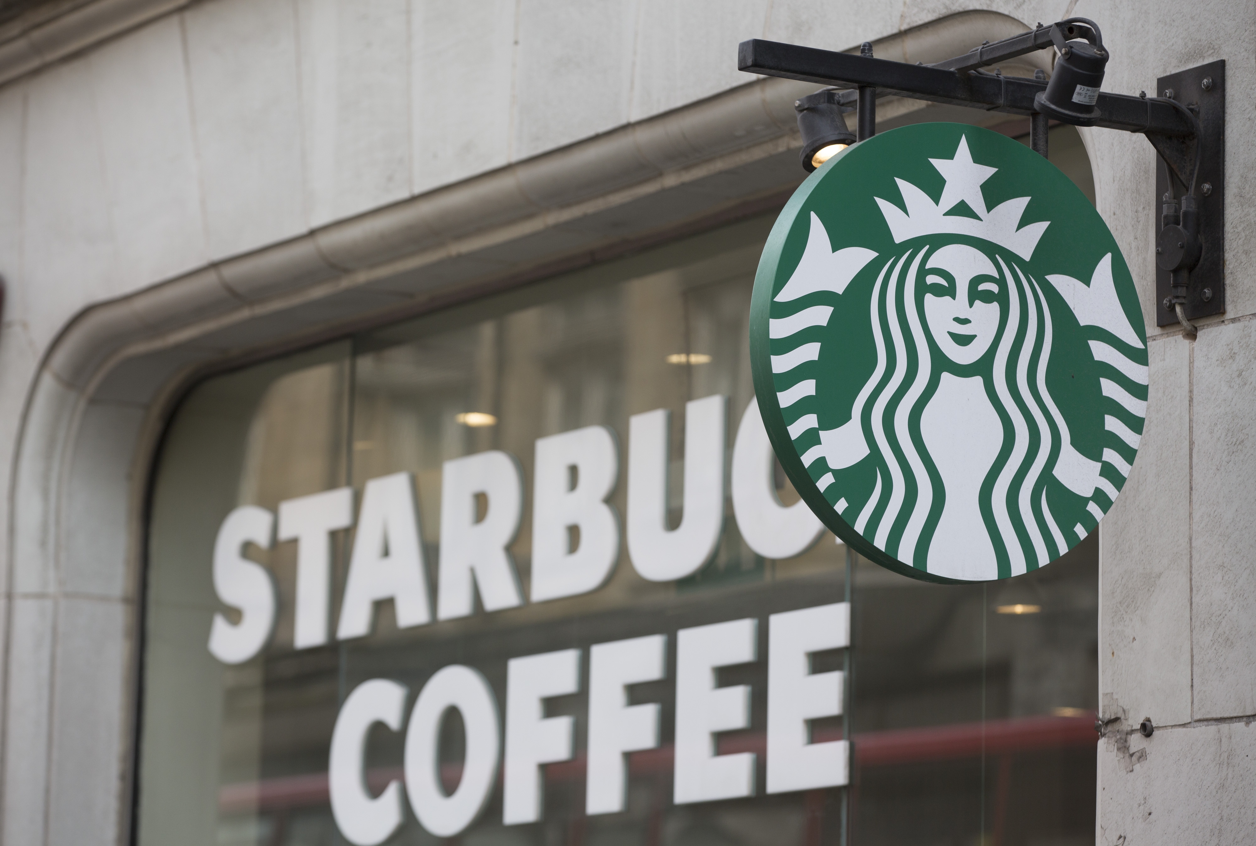 The Starbucks Corp. logo hangs outside of a coffee shop in London, U.K., on Monday, June 9, 2014. (Bloomberg&mdash;Getty Images)