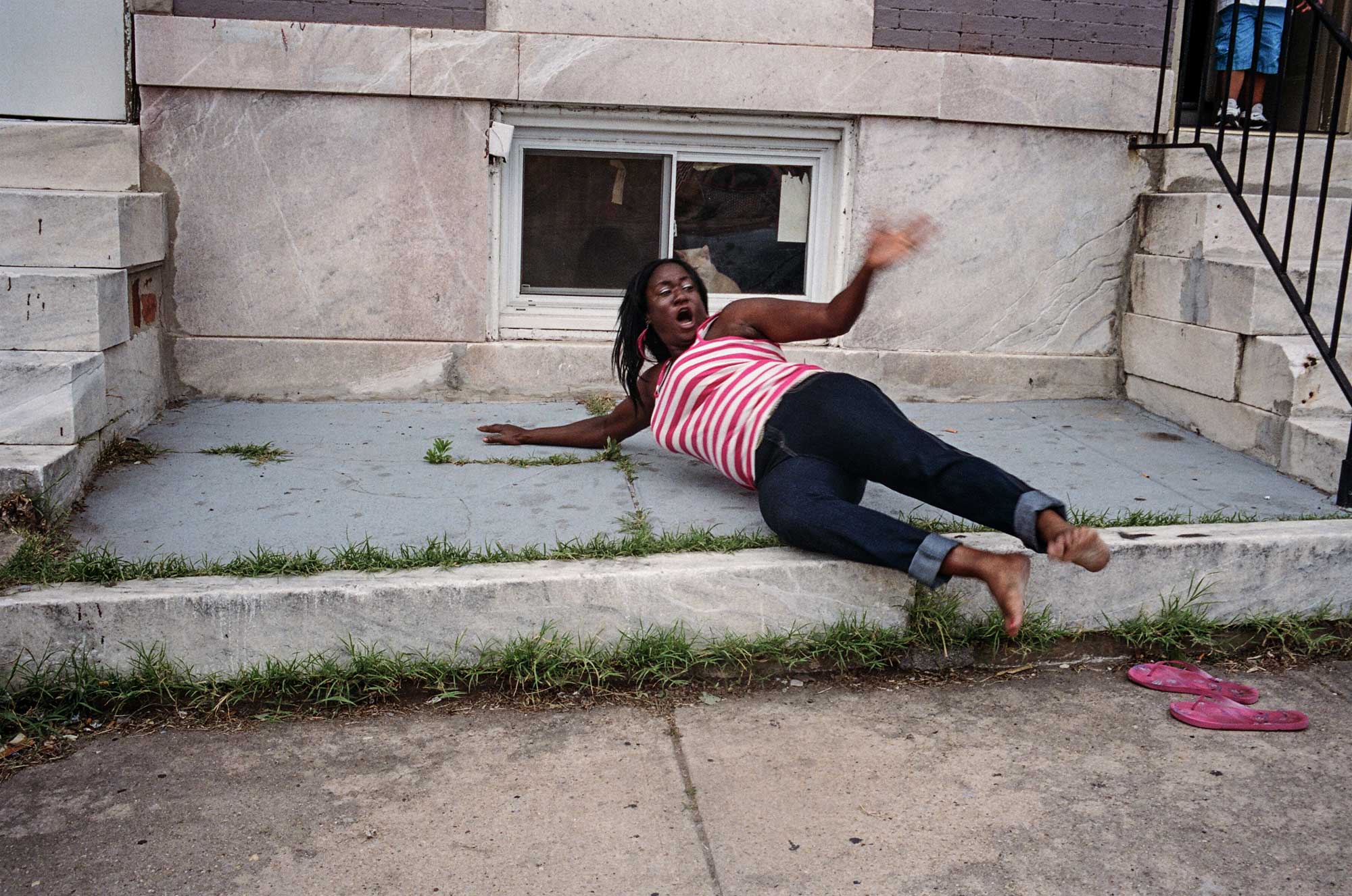 A woman hangs out in front of her house in Baltimore