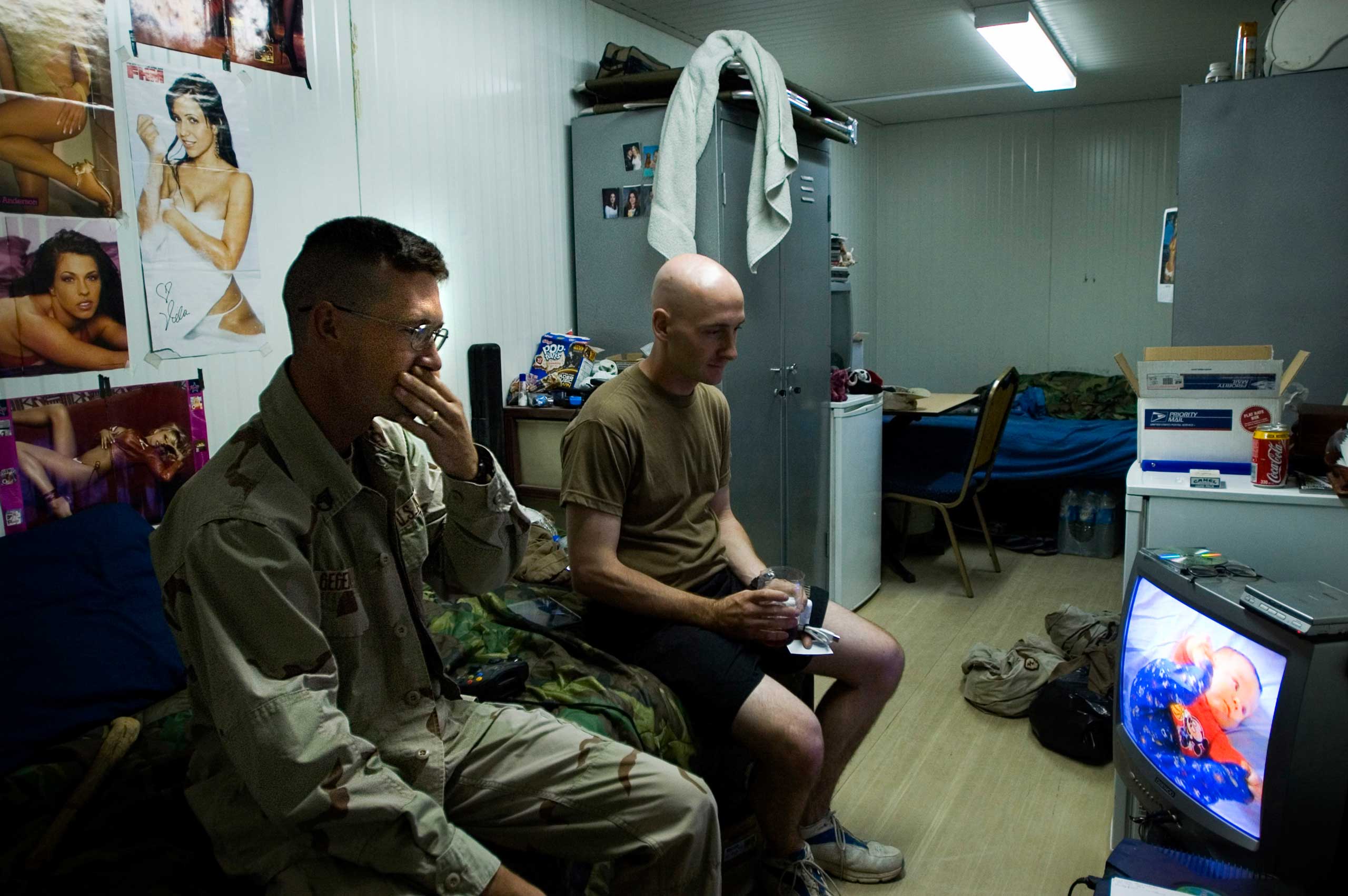 Squad Leader Michael Gegenheimer.
                              Benjamin Lowy, Aug. 19, 2005. Mosul, Iraq.
                              
                               Following the shooting death of a platoon mate during a routine patrol, Squad Leader SSG Michael Gegenheimer, left, of the Alpha Company 3-21 Stryker Battalion watches a video of his newborn child in the small trailer that has been his home for a year in Foward Operating Base Courage in Mosul, Iraq.
                              
                              I stayed with this particular unit for months documenting their lives, their routines, their fears, and their courage. Back in 2005 when I made this image, I myself was not yet a father, but I remember being tremendously touched by the Sergeant’s emotional display. Many of the soldiers in the unit choose to process their teammate’s death in different ways. Some were angry, some watched violent movies, others comedies. But looking at his newborn child was more of a reminder for Gegenheimer of what was waiting for him at home when he finally survived and left Iraq.
