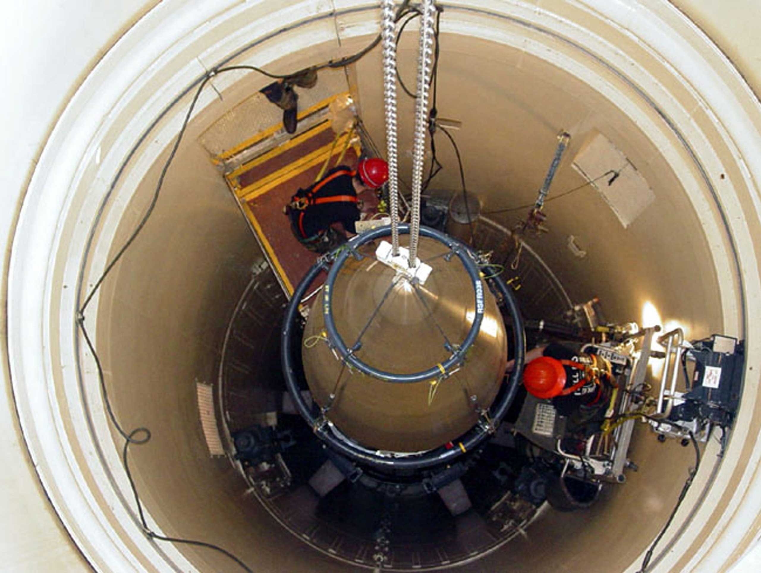 A US Air Force missile maintenance team removes the upper section of an intercontinental ballistic missile with a nuclear warhead in an undated USAF photo at Malmstrom Air Force Base, Montana.