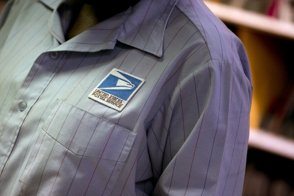 The U.S. Postal Service (USPS) logo is seen on the shirt of a letter carrier.