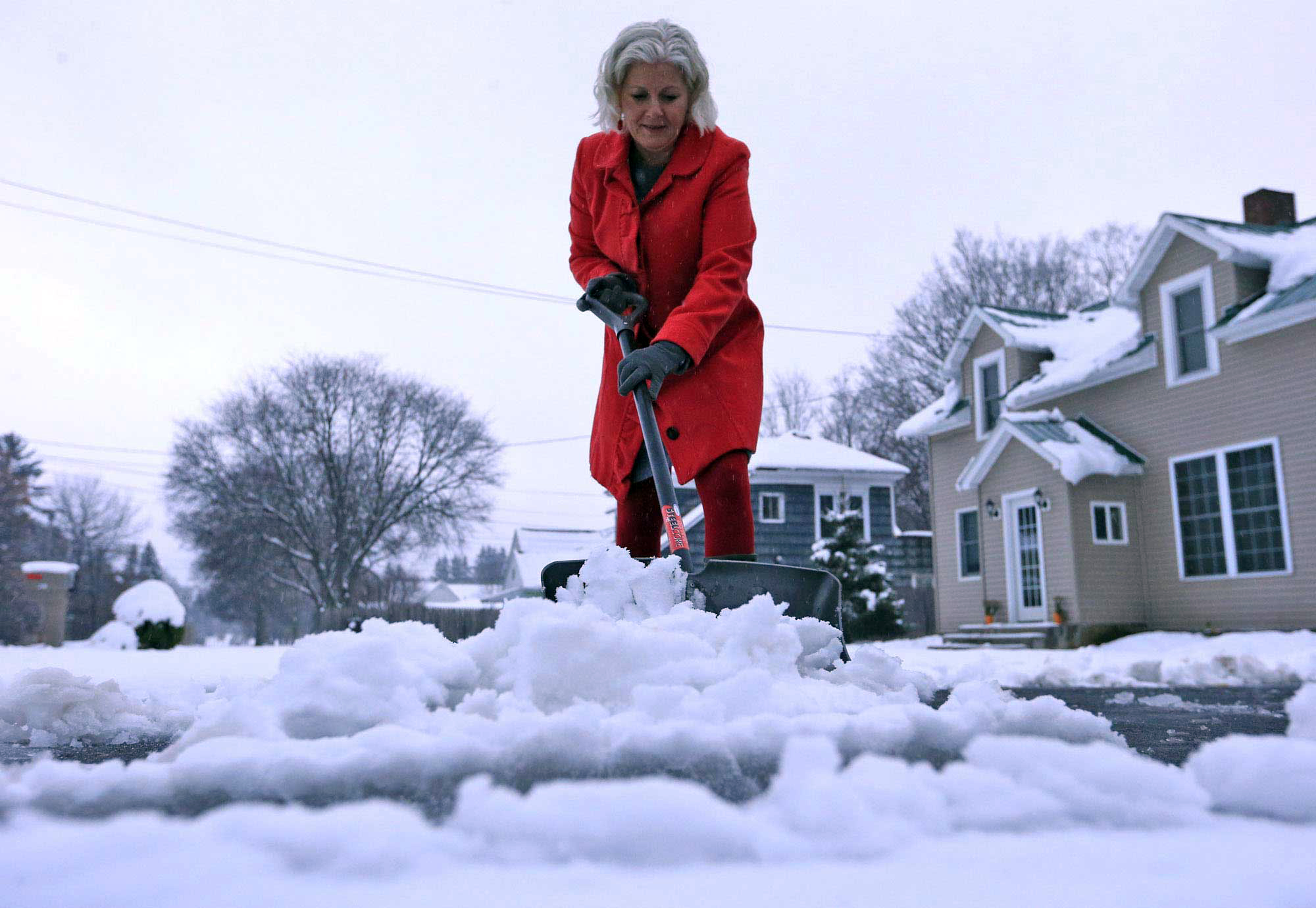 Lynette Johnson moves snow in front of her Mill Street home in Springville, NY on Nov. 17, 2014. (Harry Scull Jr.—AP)