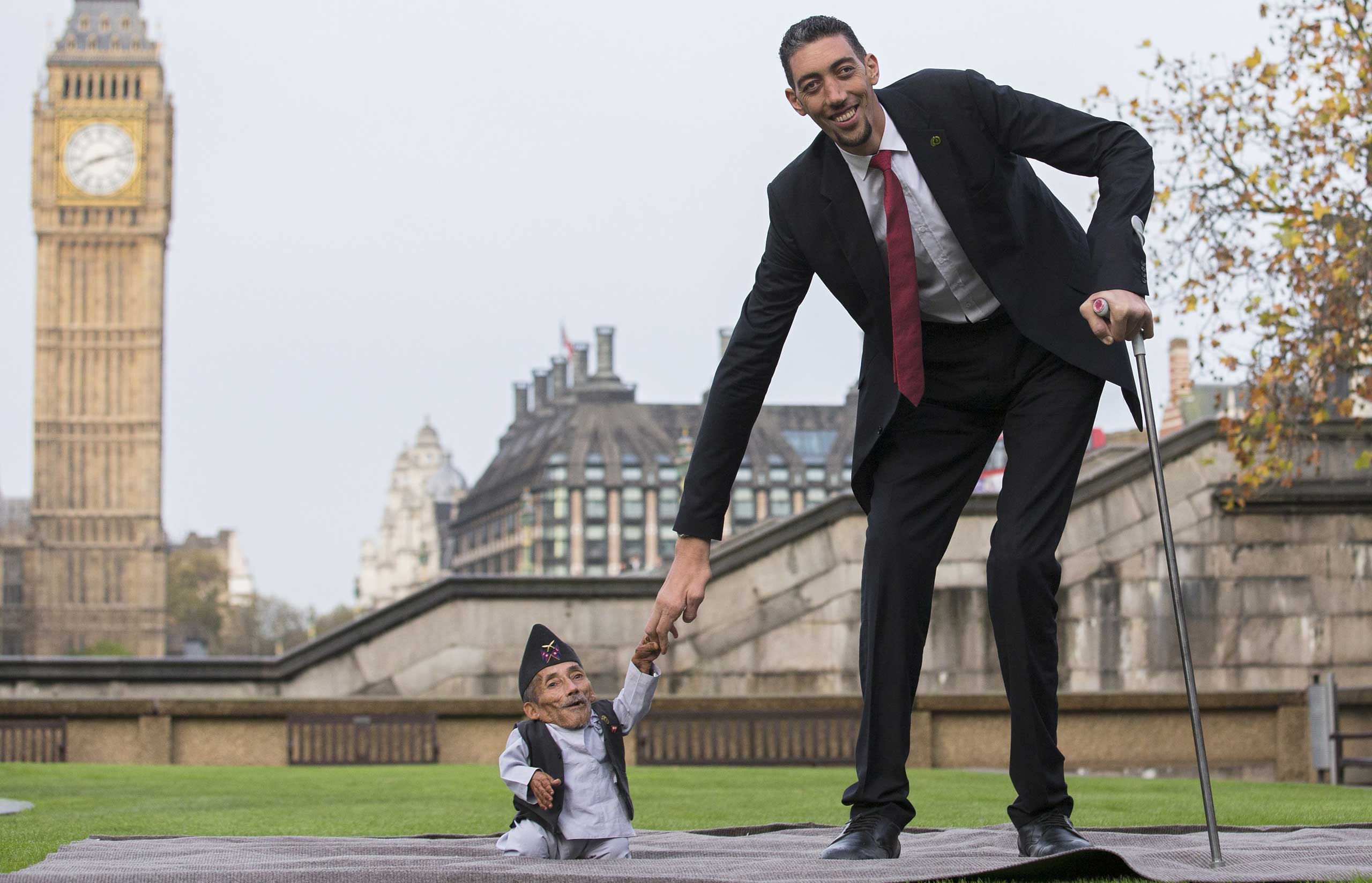 Chandra Bahadur Dangi, from Nepal, the shortest adult to have ever been verified by Guinness World Records, poses for pictures with the world's tallest man Sultan Kosen from Turkey, during a photocall in London on Nov. 13, 2014, to mark Guinness World Records Day. (Andrew Cowie—AFP/Getty Images)