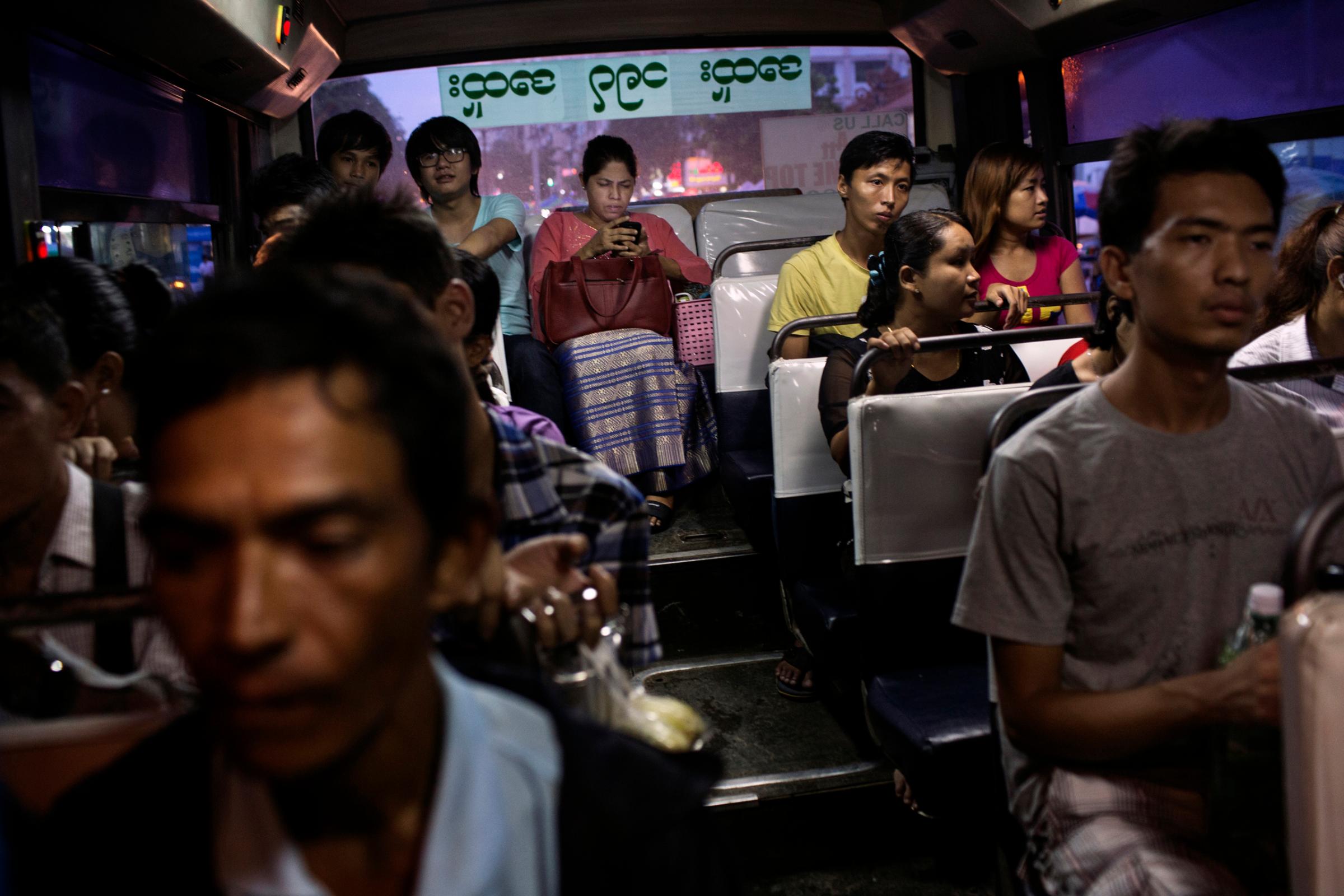 Passengers, some using smart phones, ride a bus in Yangon, Burma, June 21st, 2014.