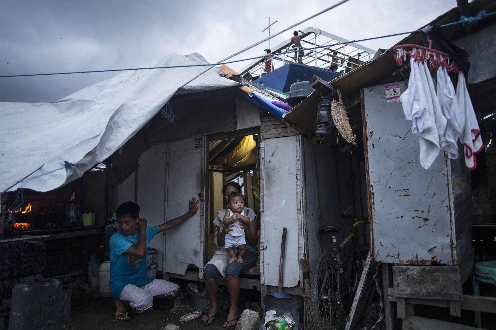 Eric and Roby Mameta by their house in Tacloban, in the Philippines, on Oct. 8, 2014, next to one of the ships that were washed ashore by supertyphoon Haiyan (Per Liljas)