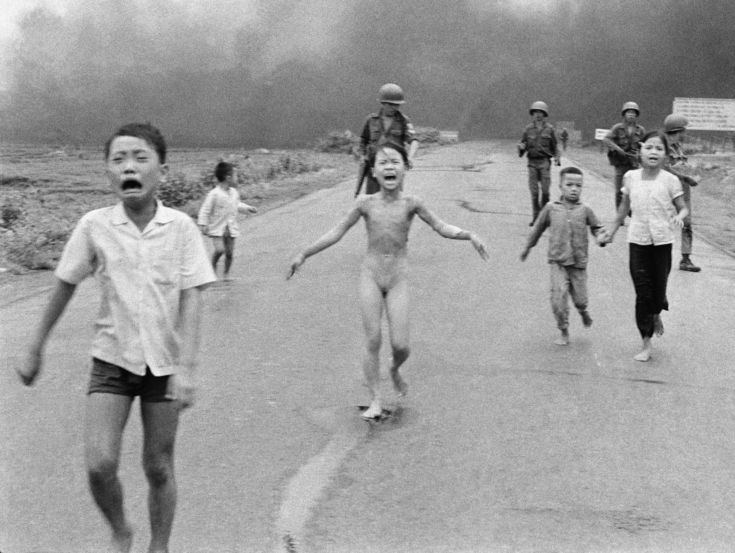 South Vietnamese forces follow after terrified children, including 9-year-old Kim Phuc, center, as they run down Route 1 near Trang Bang after an aerial napalm attack on suspected Viet Cong hiding places on June 8, 1972.