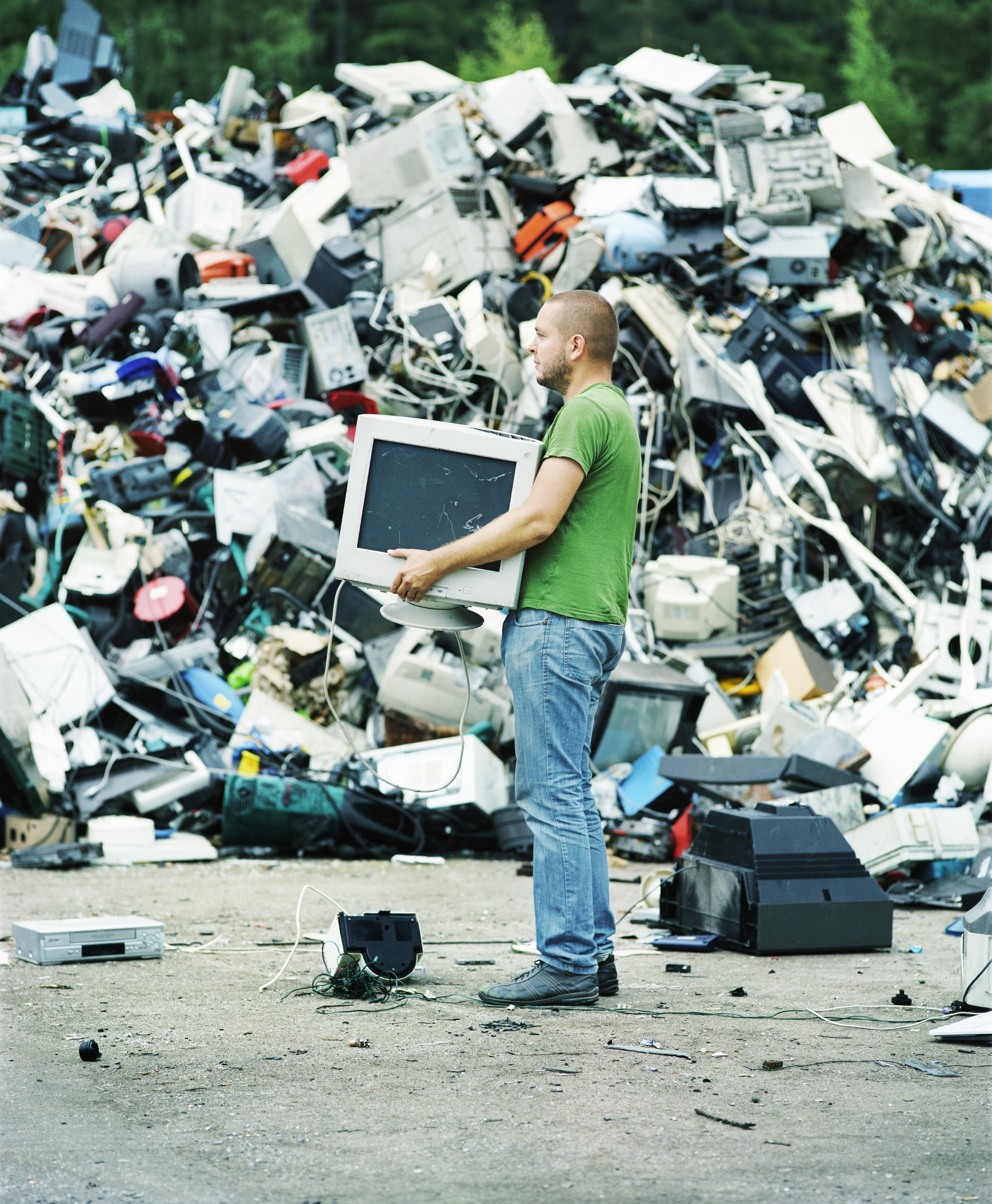 Man holding a computer monitor at a recycling center (Lauri Rotko&mdash;Getty Images/Gorilla RM)