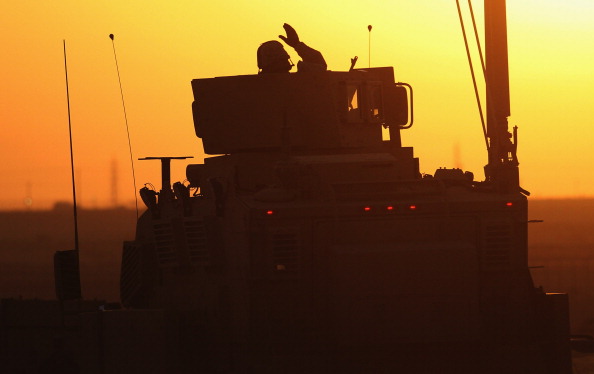 A U.S. soldier waves as the final American convoy pulls out of Iraq in 2011 at the end of the second Iraq war. (Mario Tama / Getty Images)