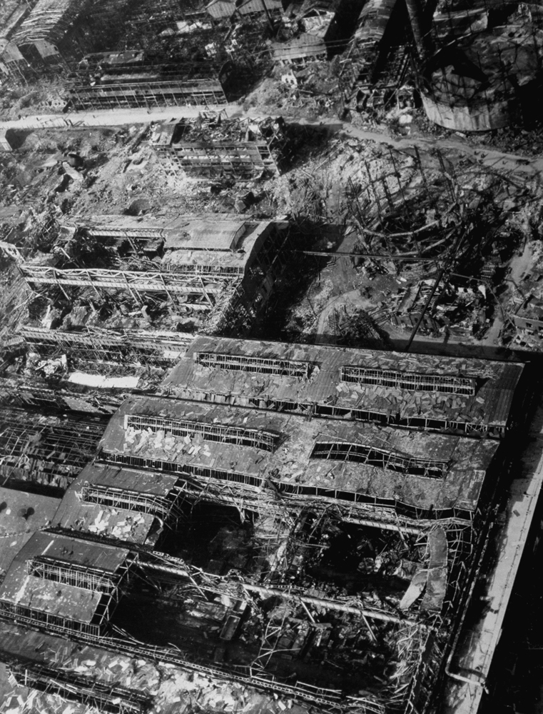 The picture above shows the center of the Krupp Compound [Essen], with wrecked steel mills (foreground) and blasted gas tanks (right background).
