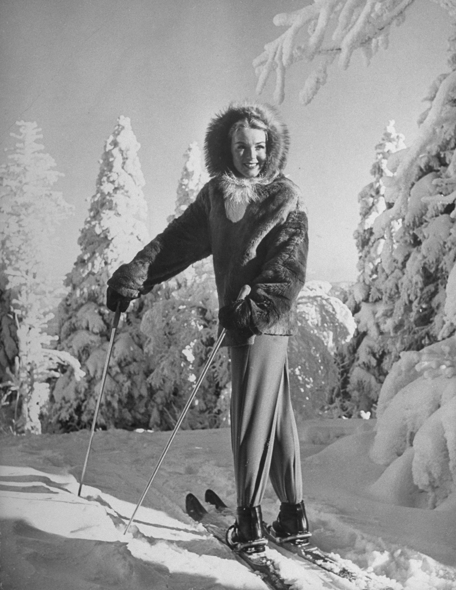 For skiing at 40 degrees below zero Blanche [Rybizka] wears a deerhide jacket, a raccoon-edged hood, fur-lined mittens and two pairs of underwear under her trim pants.