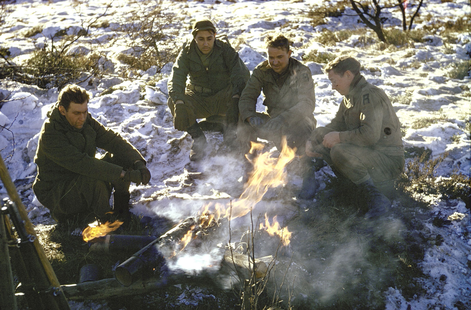 Allied troops around a fire in the Ardennes Forest during the Battle of the Bulge.