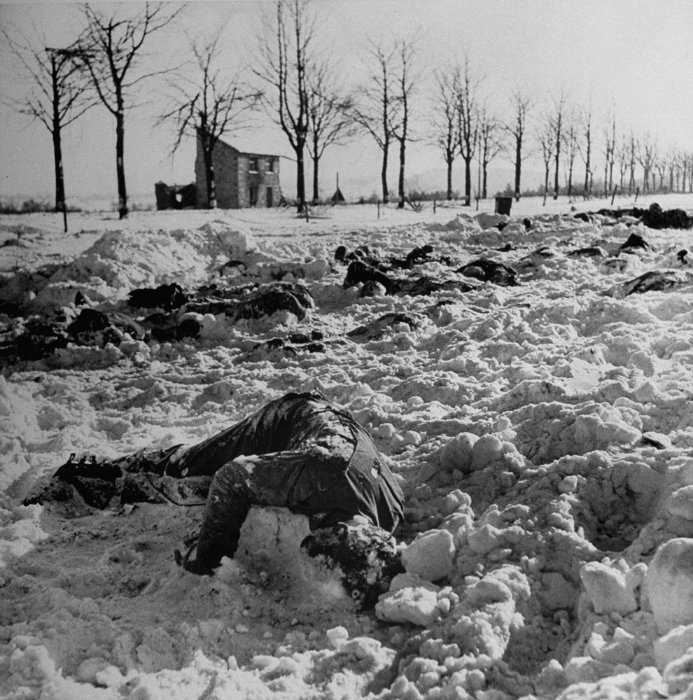 Some of the 115 Americans who, LIFE reported, were "massacred at point-blank range" in a field after being captured by Germans in the early days of the Battle of the Bulge, 1944. The soldiers were herded into a field and machine-gunned; when found, many of the frozen bodies still had their hands above their heads.