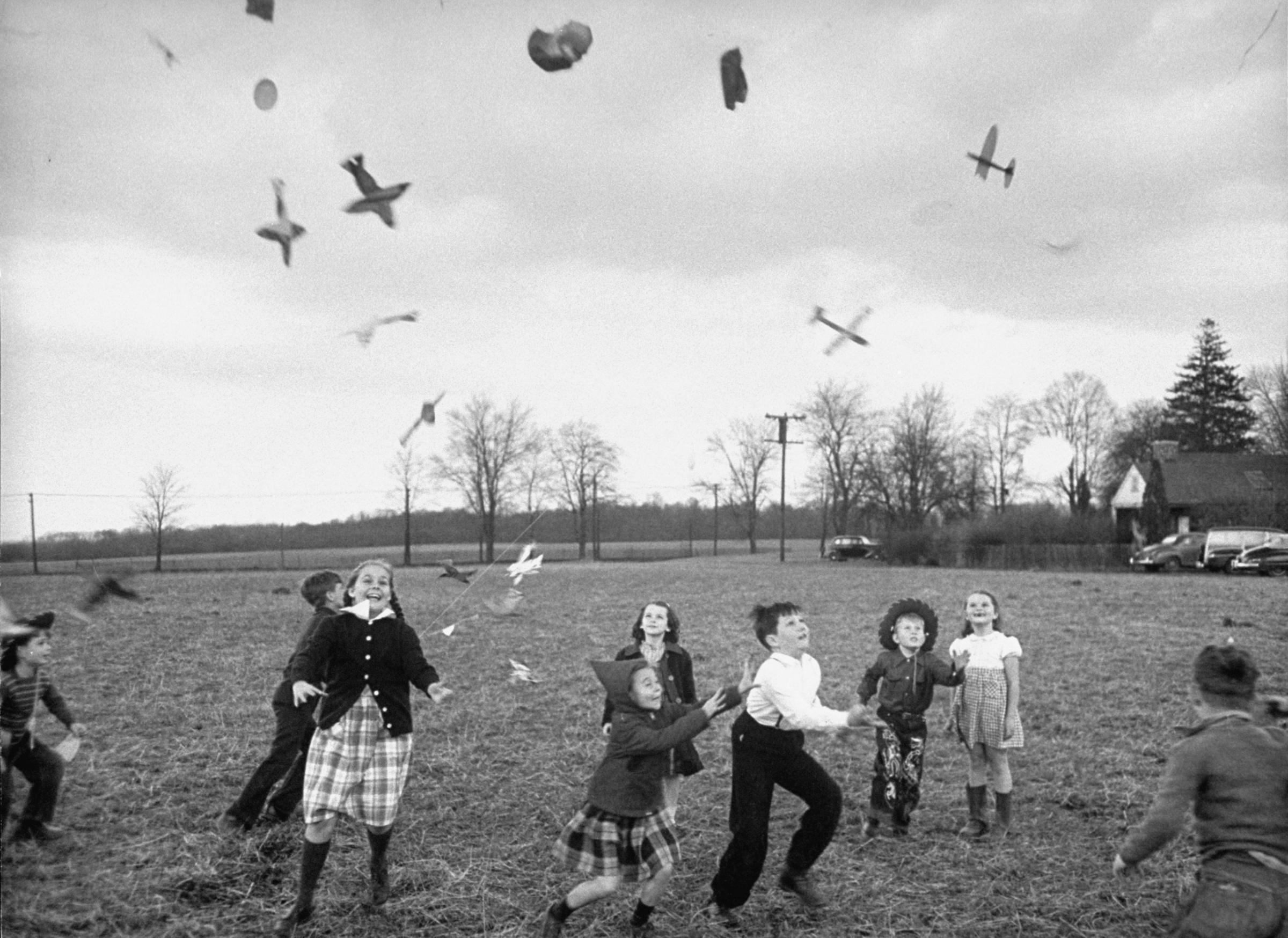 Children try to catch toys that were released by a kite, 1949.
