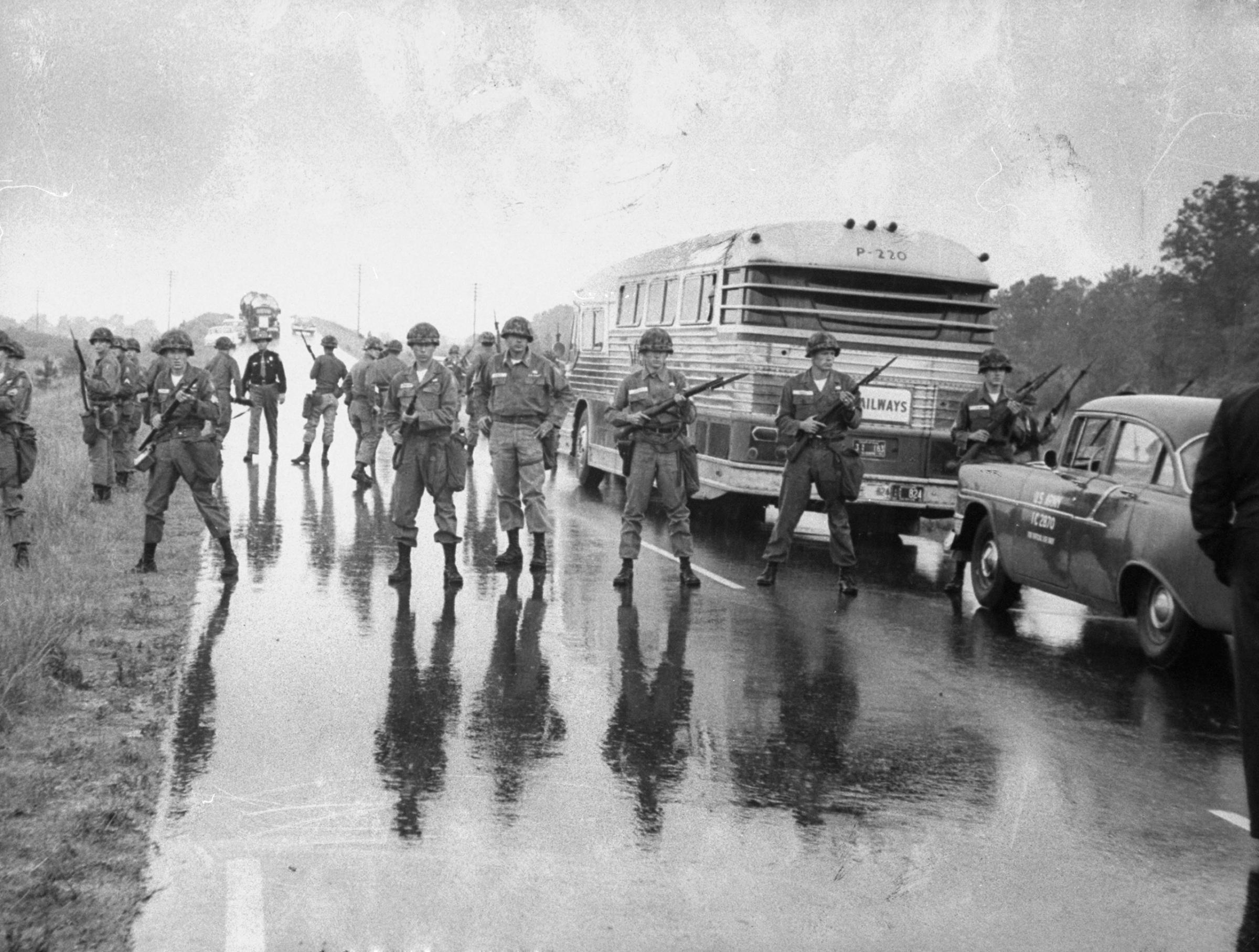 Just shy of the Mississippi-Alabama border, members of the Alabama National Guard surround a bus carrying freedom riders.