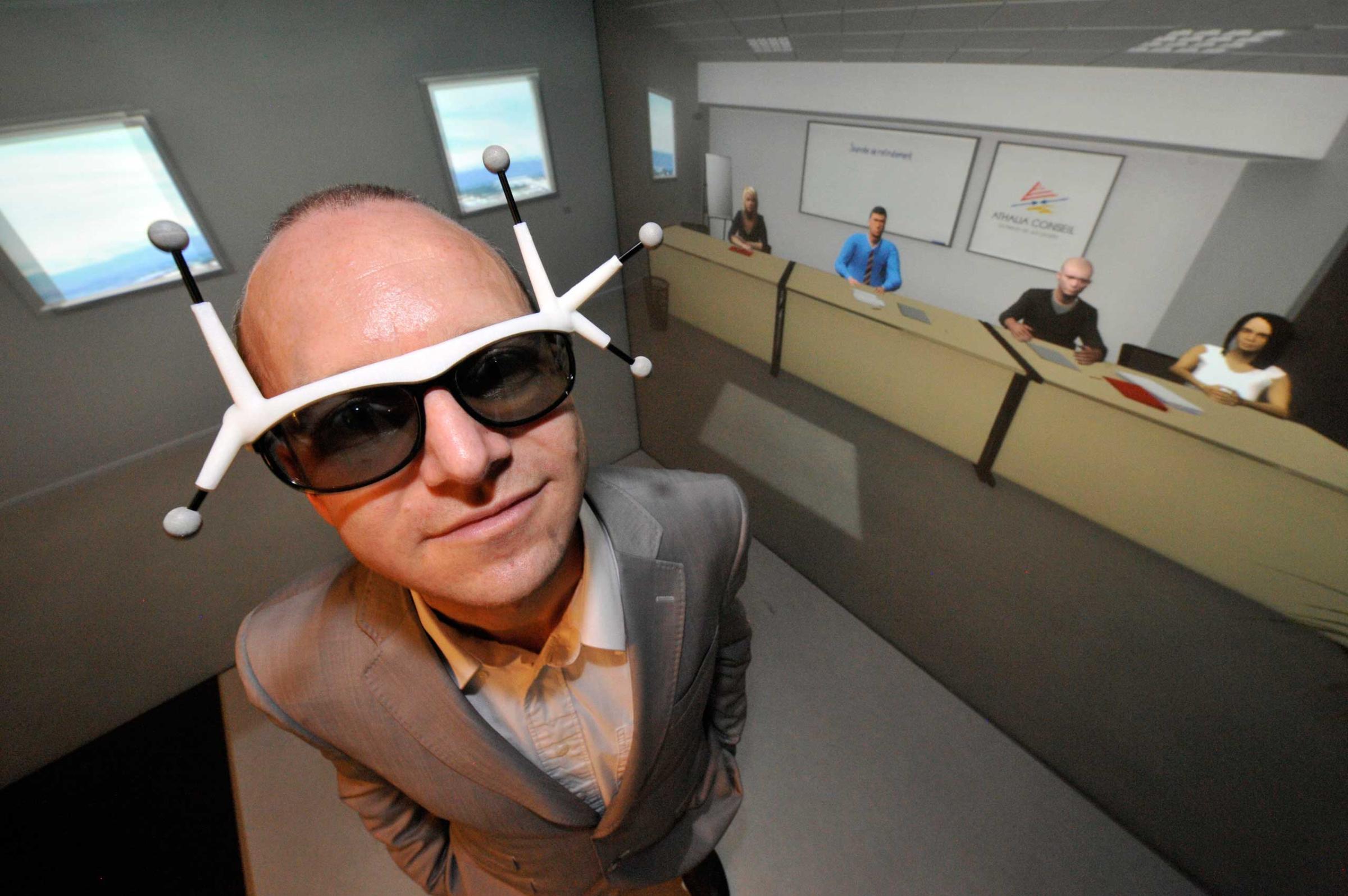 A man seeking a job was equipped with 3D spectacles with sensors as he trained in Clermont-Ferrand, central France with avatars (background) in a virtual reality cube, at business incubator Pascalis.