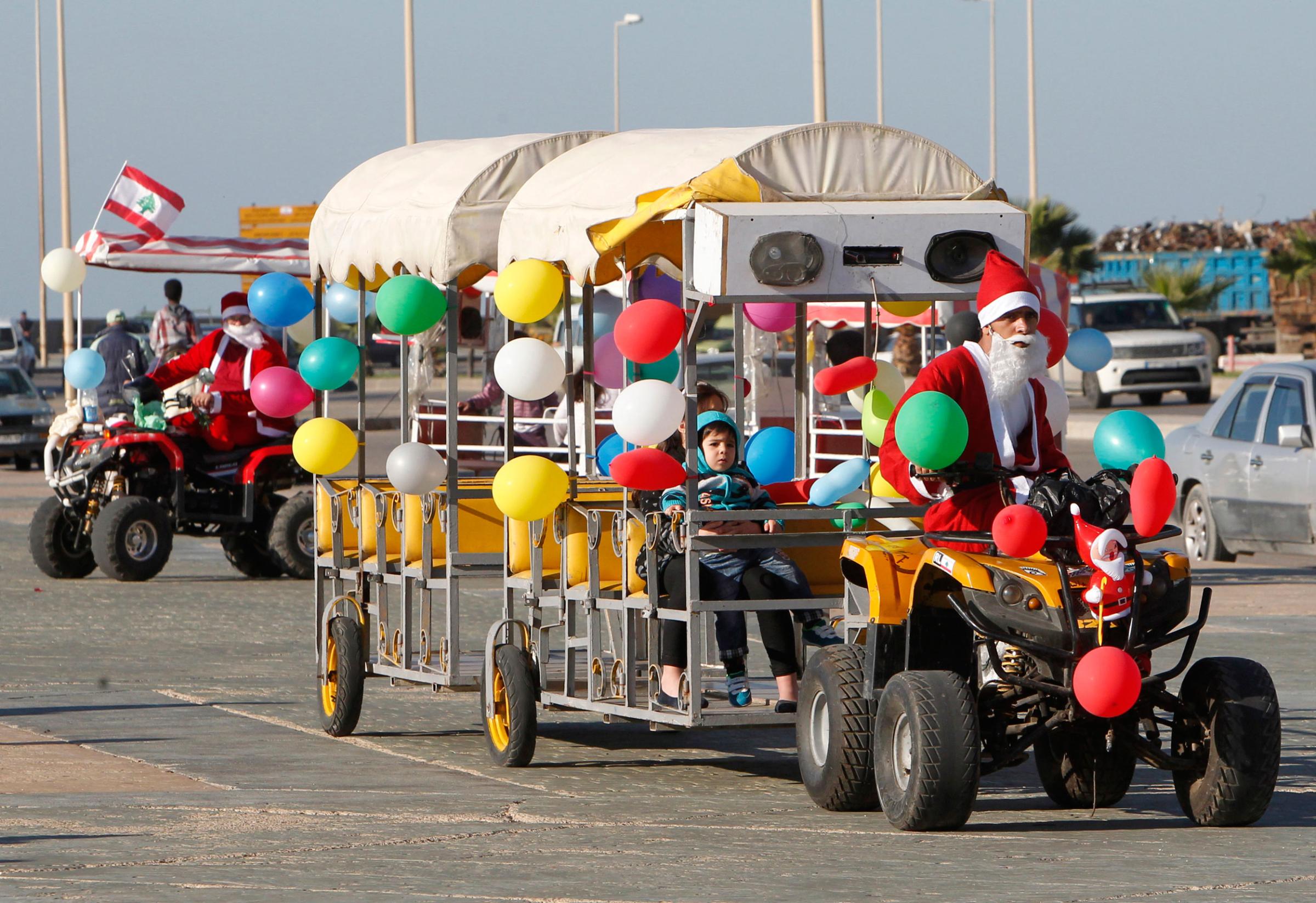A man dressed as Santa Claus drives a vehicle during Christmas day in Sidon, South Lebanon on Dec. 25, 2014.