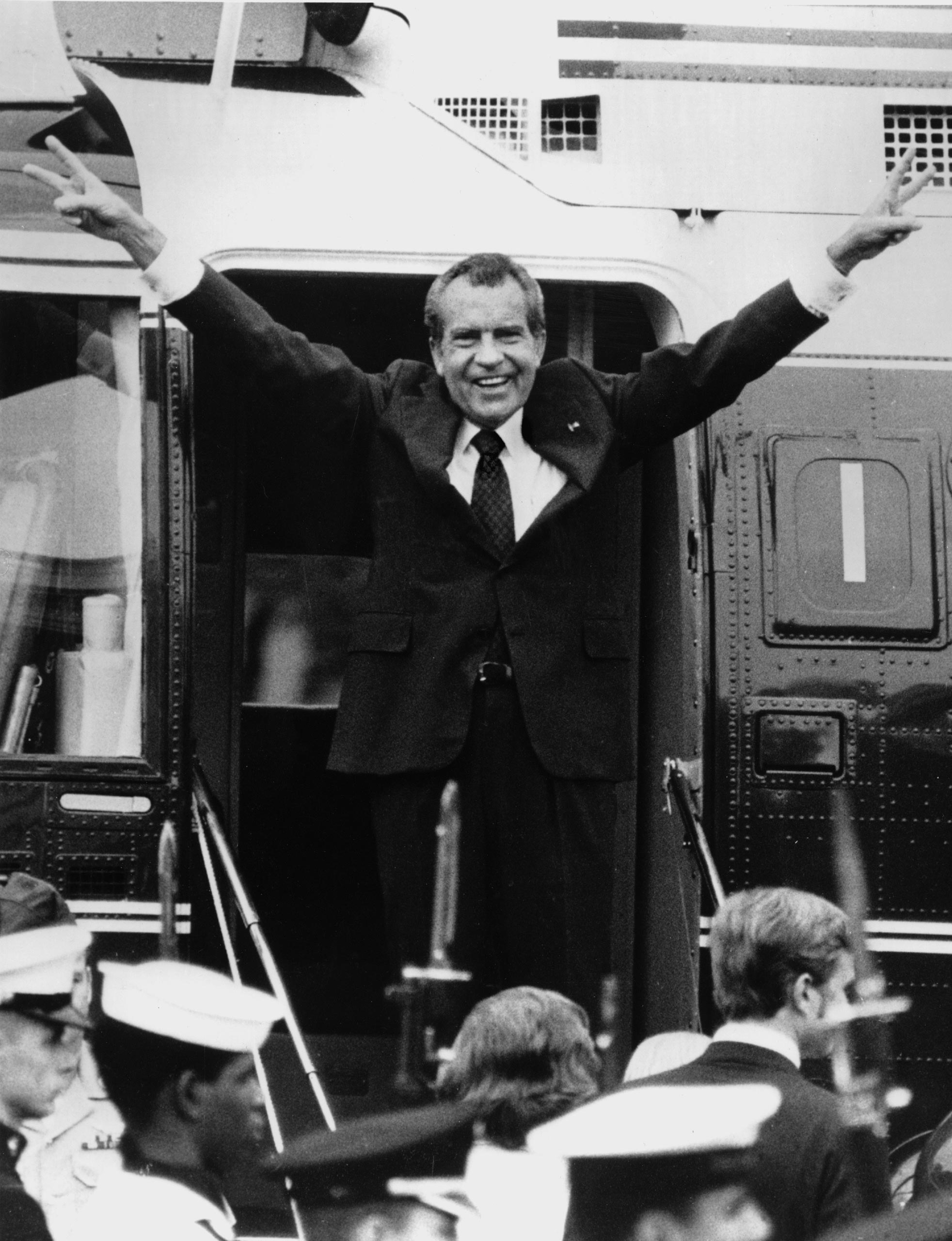 Richard Nixon says goodbye with a victorious salute to his staff members outside the White House as he boards a helicopter after resigning the presidency on Aug. 9, 1974.