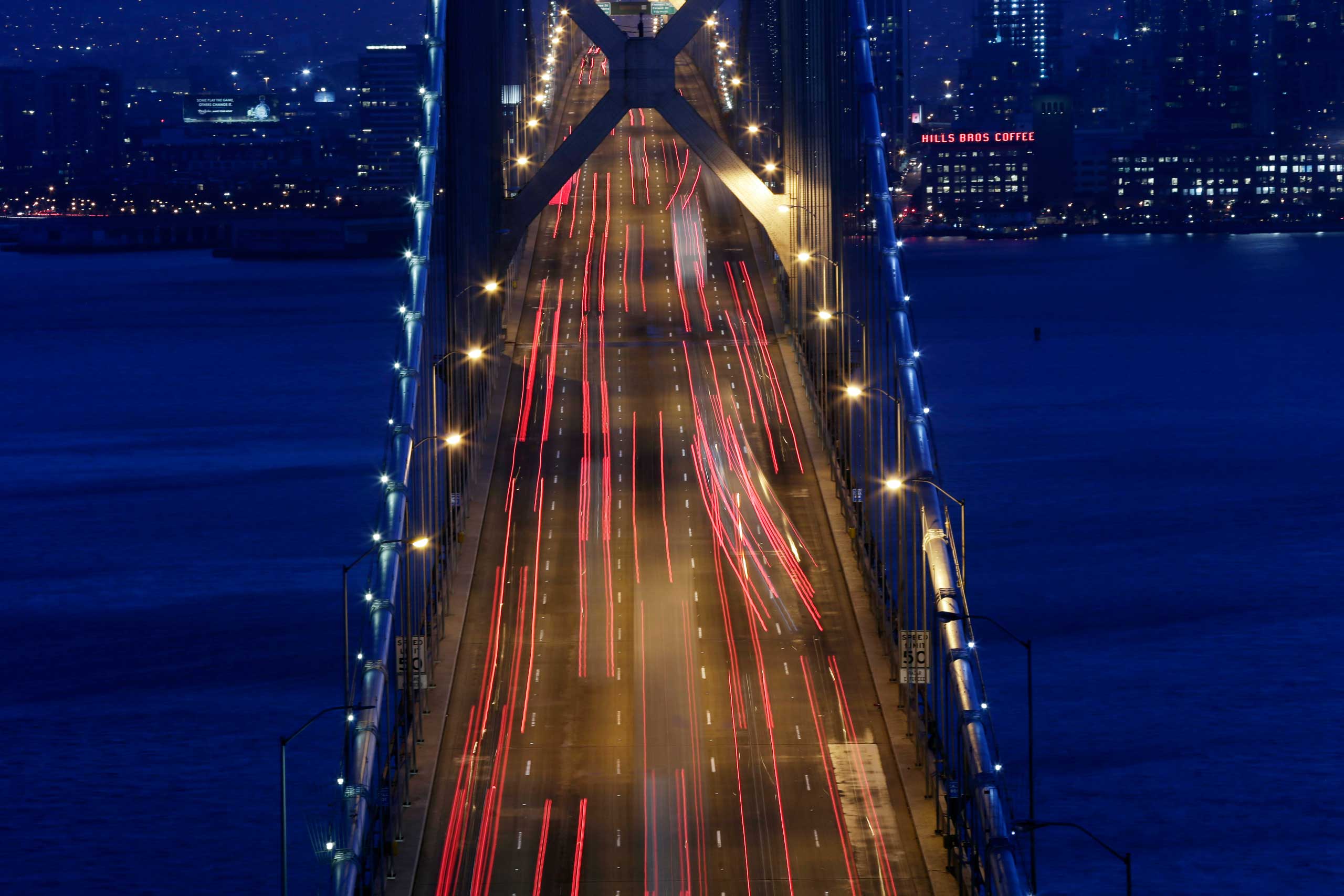 In this Sept. 3, 2014, picture made with a long exposure, lights from evening rush hour traffic move over the San Francisco Oakland Bay Bridge in San Francisco.