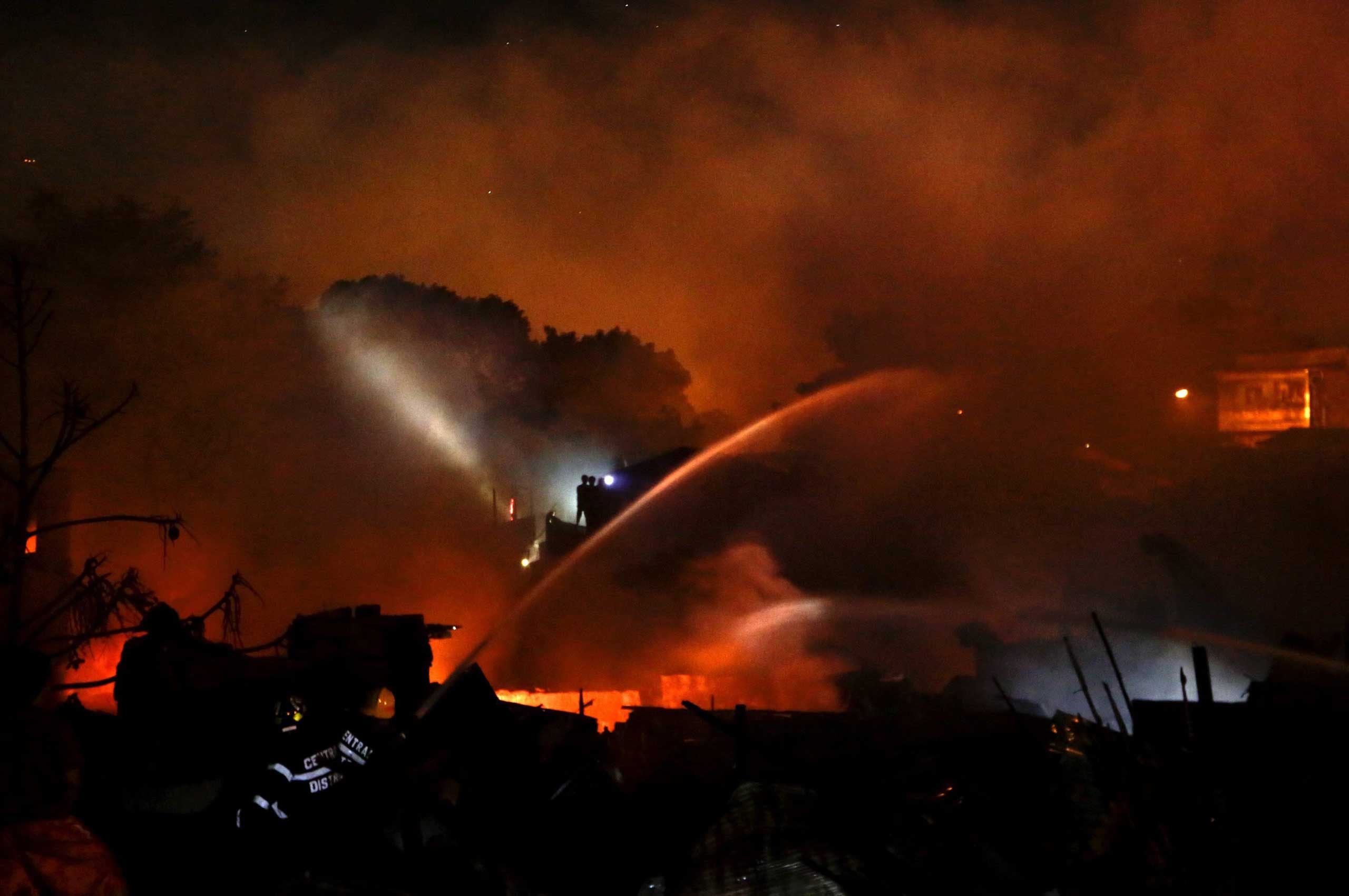 Filipino firemen use water cannon to extinguish a fire in a residential slum area in Quezon City, east of Manila, Philippines, May 6, 2014. T