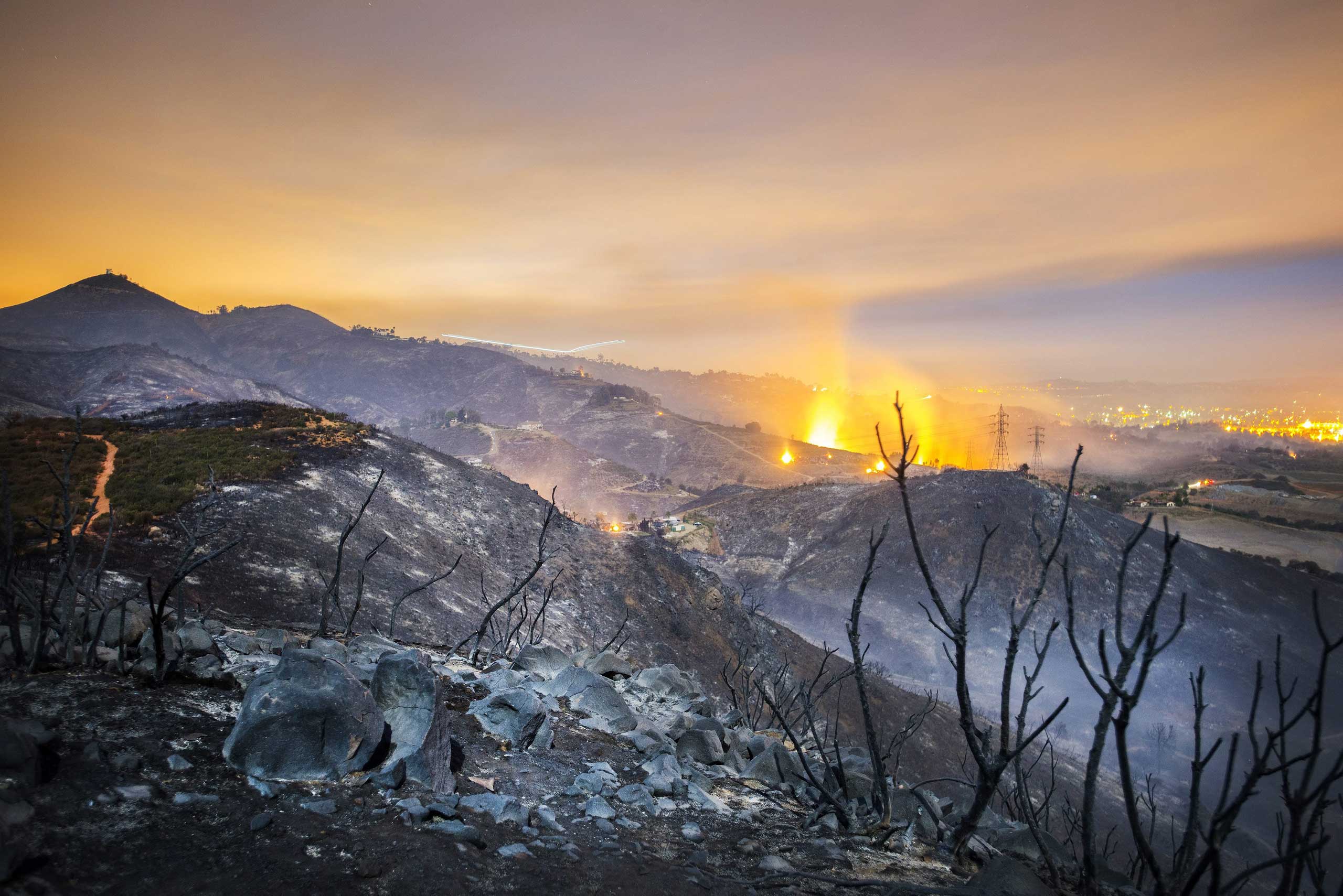 A long exposure shows smolderings remains of overnight fires on the hillsides of San Marcos, San Diego county, California, USA, early May 16, 2014.