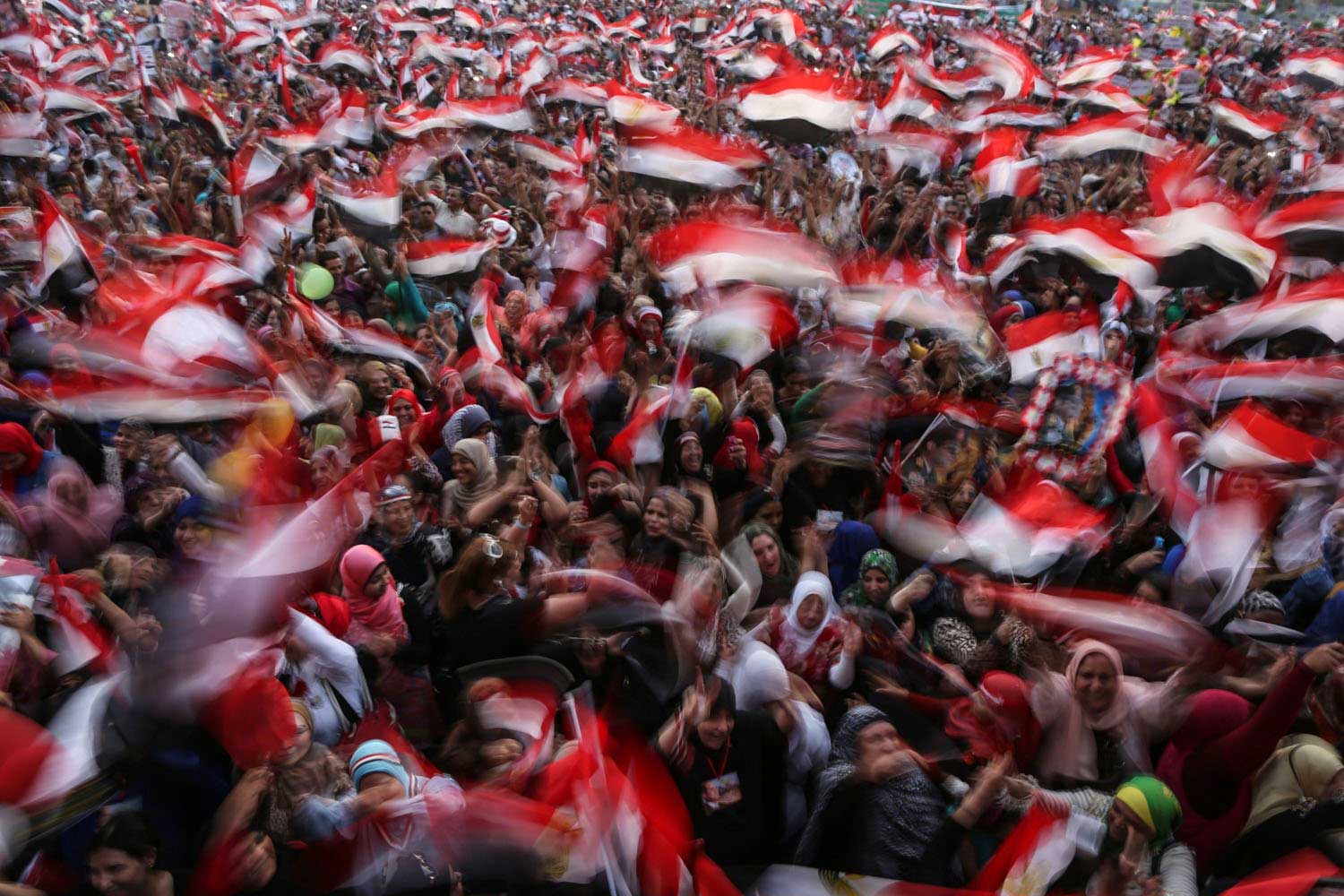 Egyptians wave national flags as they celebrate in Cairo's Tahrir Square on June 3, 2014 after ex-army chief Abdel Fattah al-Sisi won 96.9 percent of votes in Egypt's presidential election.