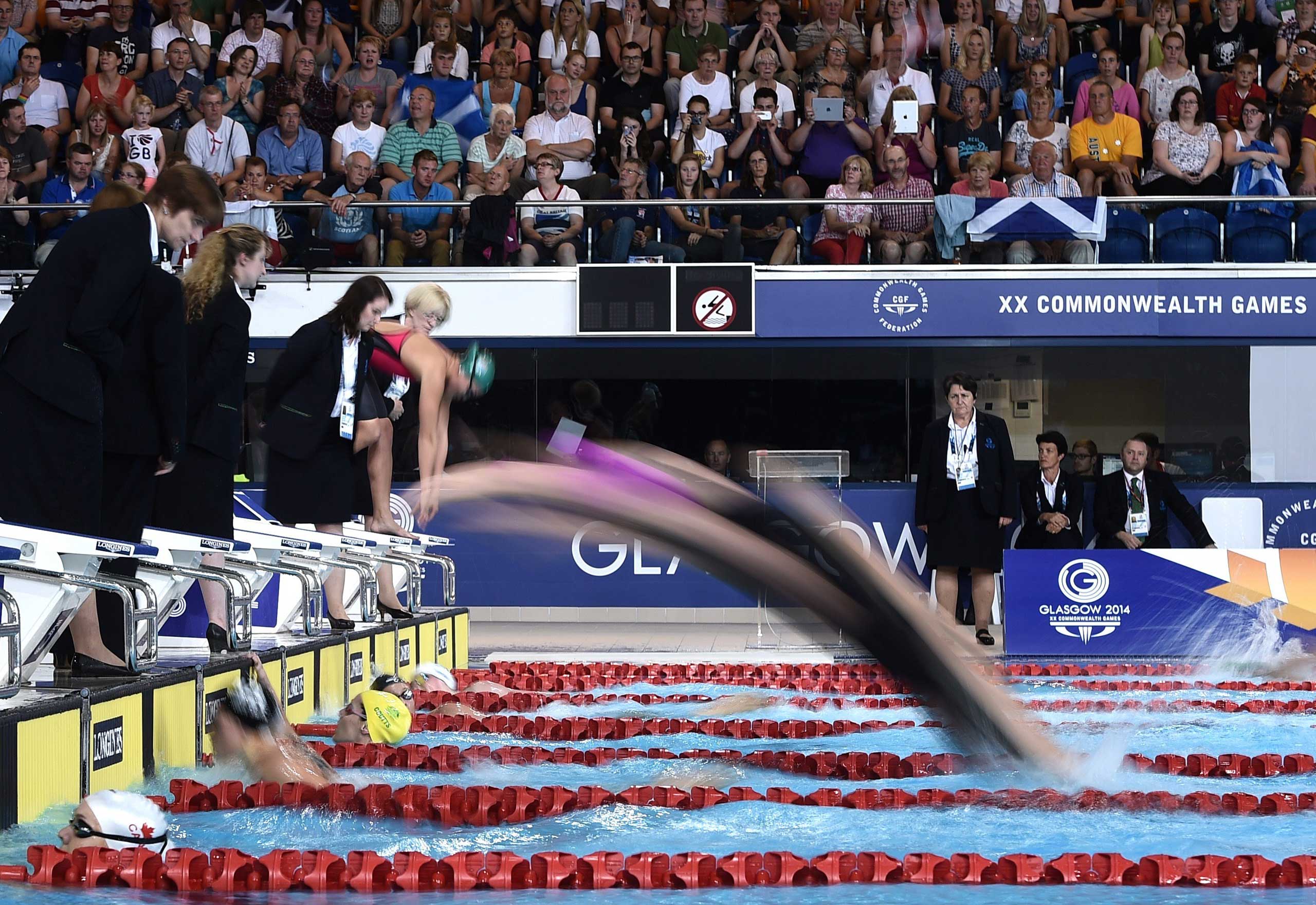 Swimmers dive in during the Women's 4 x 200m Freestyle Relay Final at the Tollcross International Swimming Centre during the 2014 Commonwealth Games in Glasgow on July 26, 2014.
