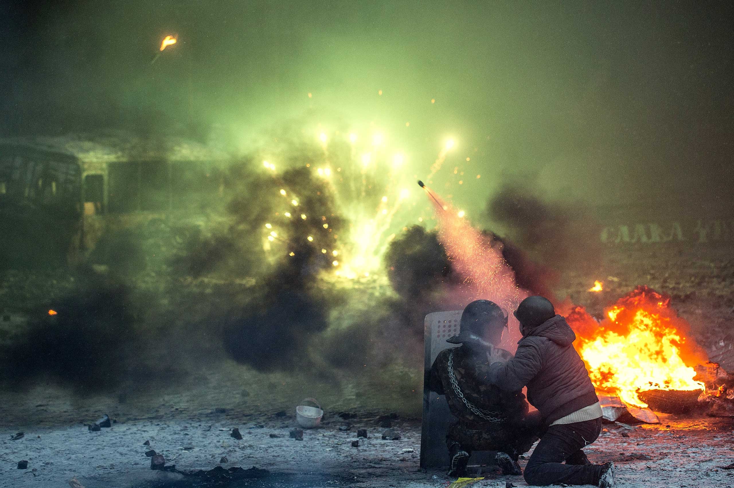 Ukrainian protesters shoot with a help of petards amongst burning automobile tires during a mass action of opposition on Grushevsky street against laws recently accepted by the Verkhovna Rada that toughen requirements to carrying out mass meetings and restrict journalists activity, on Jan. 22, 2014 in Kiev, Ukraine.