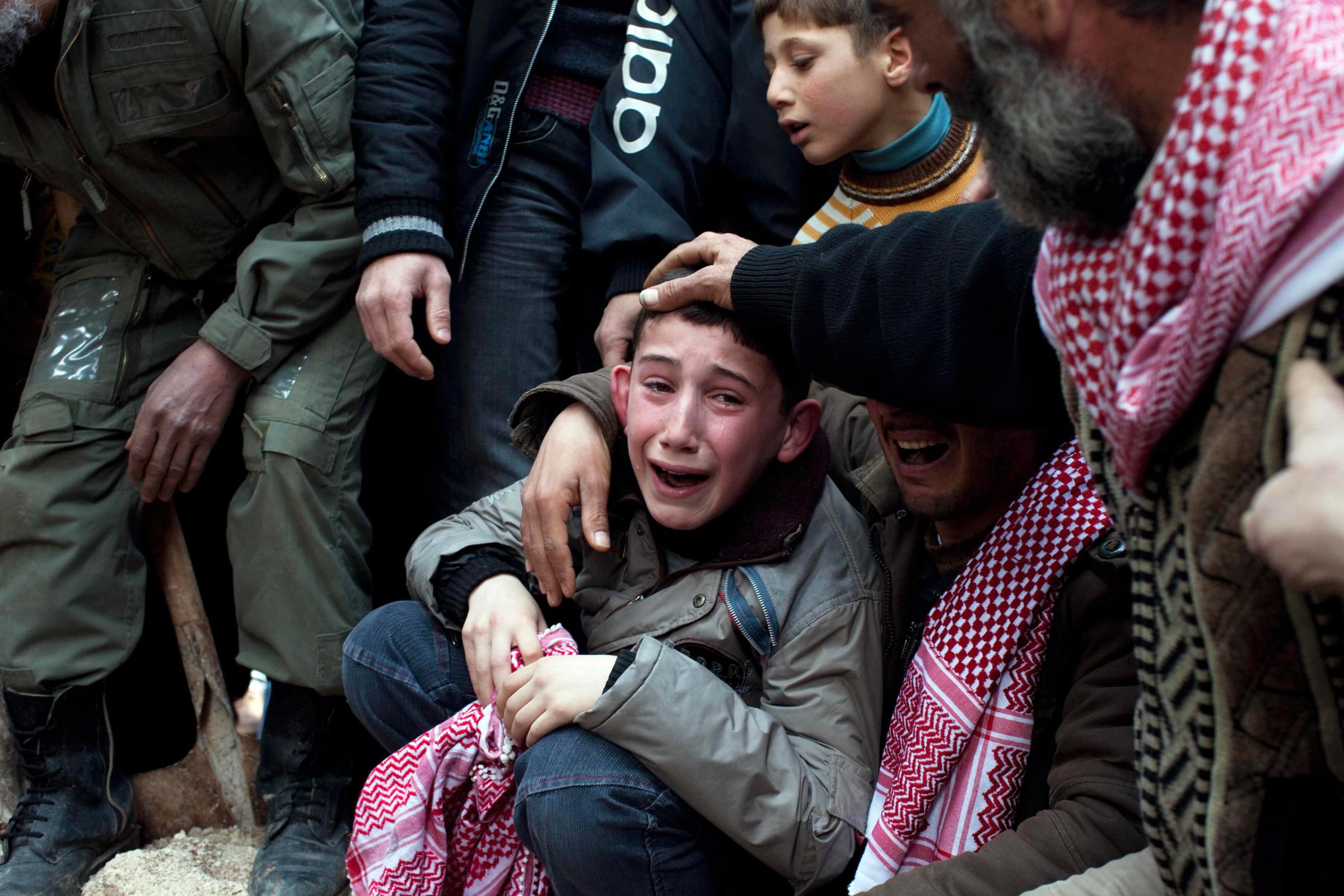 Ahmed, center, mourns his father Abdulaziz Abu Ahmed Khrer, who was killed by a Syrian Army sniper, during his funeral in Idlib, north Syria, on March 8, 2012.