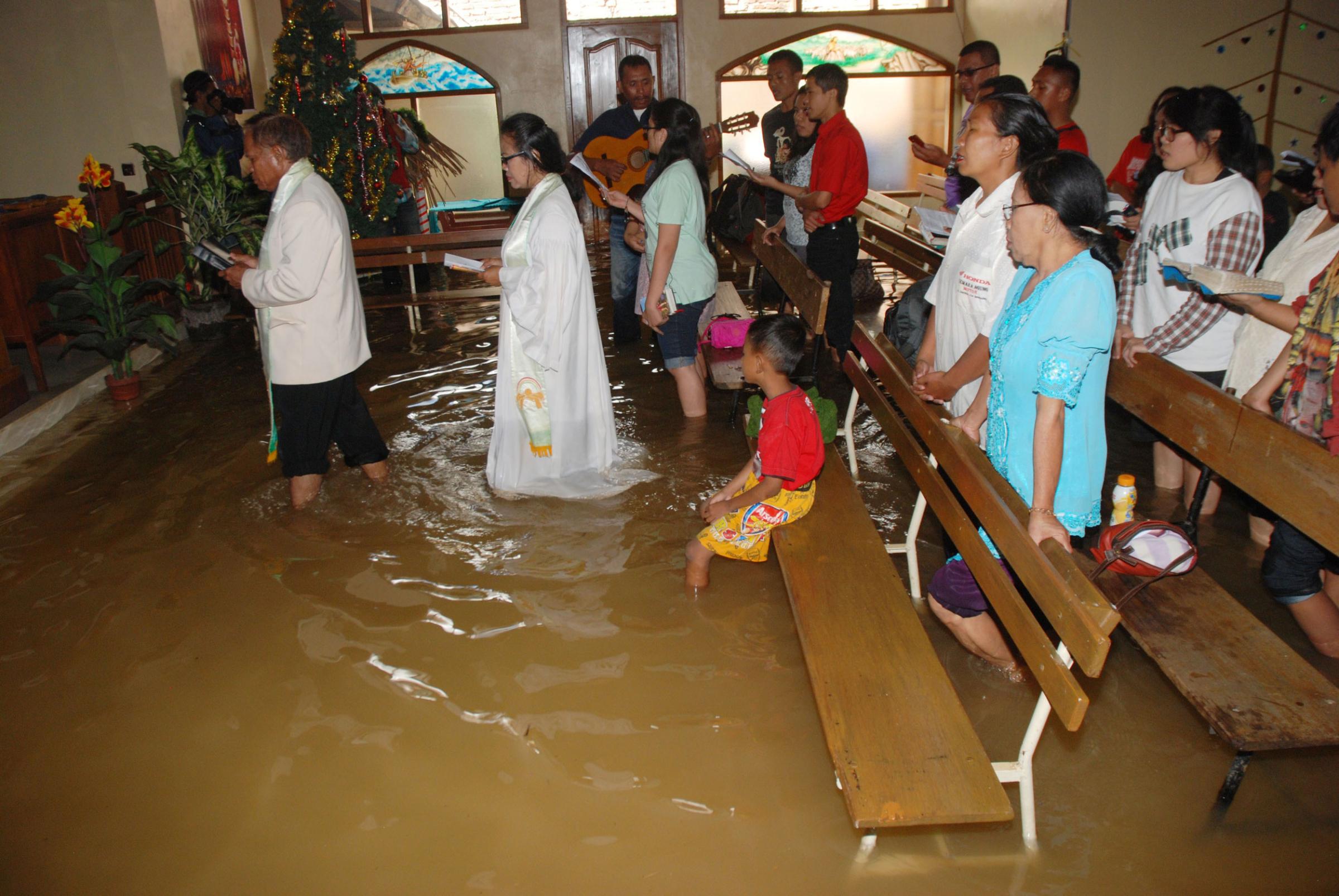 Christians attend the mass service at a flooded church in Bandung, in western Java island, on Dec. 25, 2014.