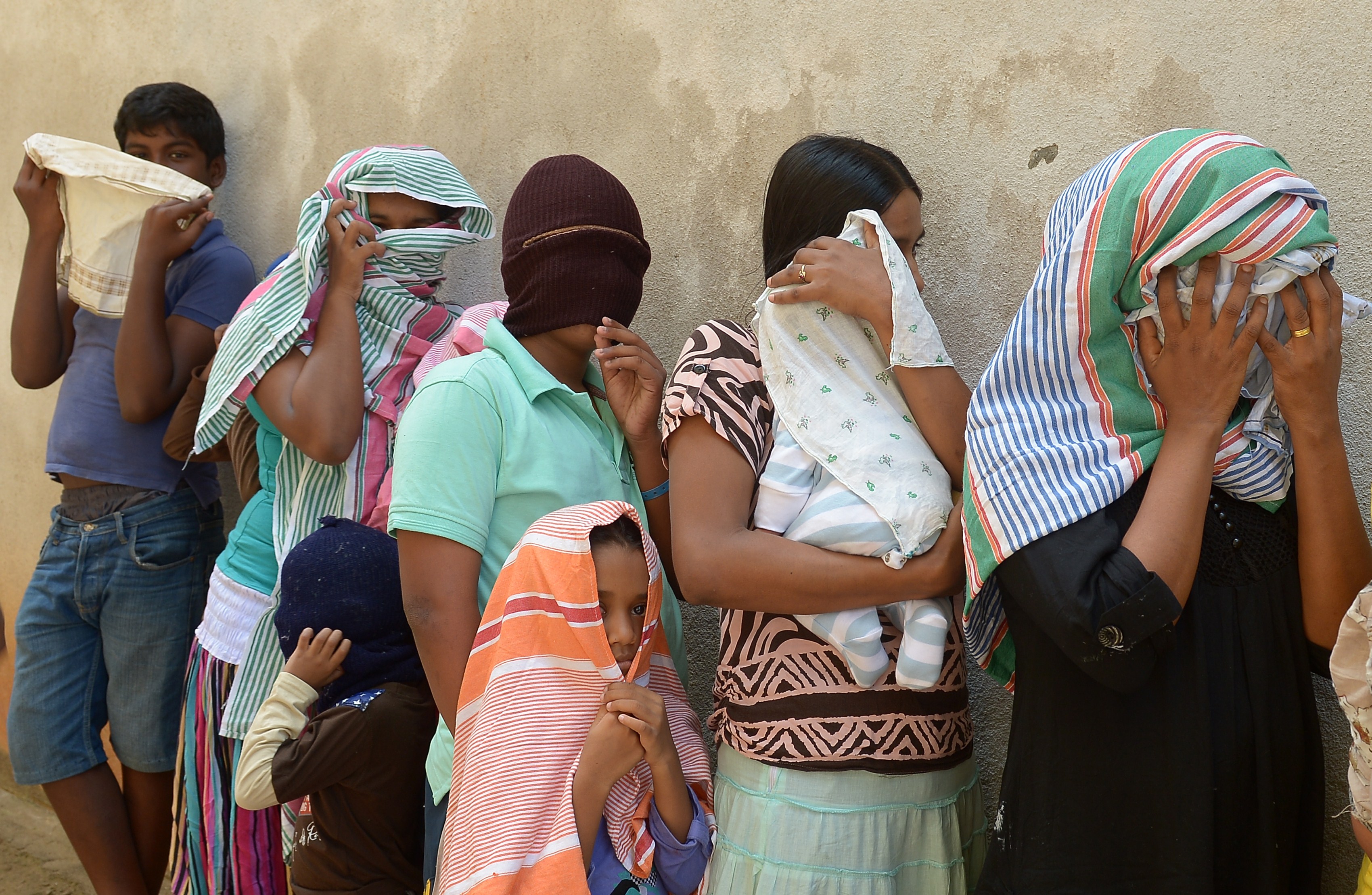 Sri Lankan asylum seekers sent back by Australia queue to enter the magistrate's court in the southern port district of Galle on July 8, 2014. (Lakruwan Wanniarachchi —AFP/Getty Images)