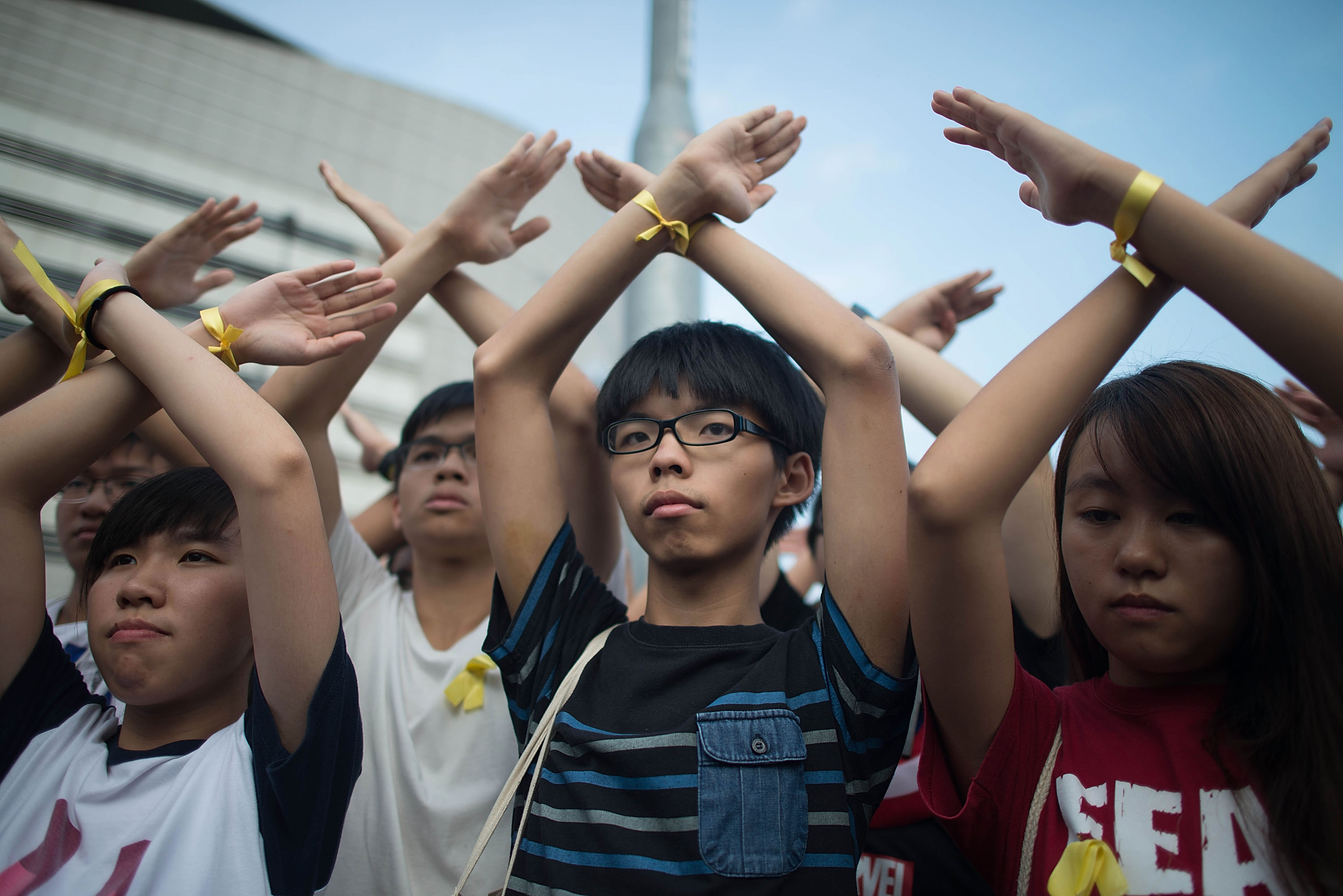Student pro-democracy group Scholarism convenor Joshua Wong (C) makes a gesture at the Flag Raising Ceremony at Golden Bauhinia Square on October 1, 2014 in Hong Kong. (Anthony Kwan—Getty Images)