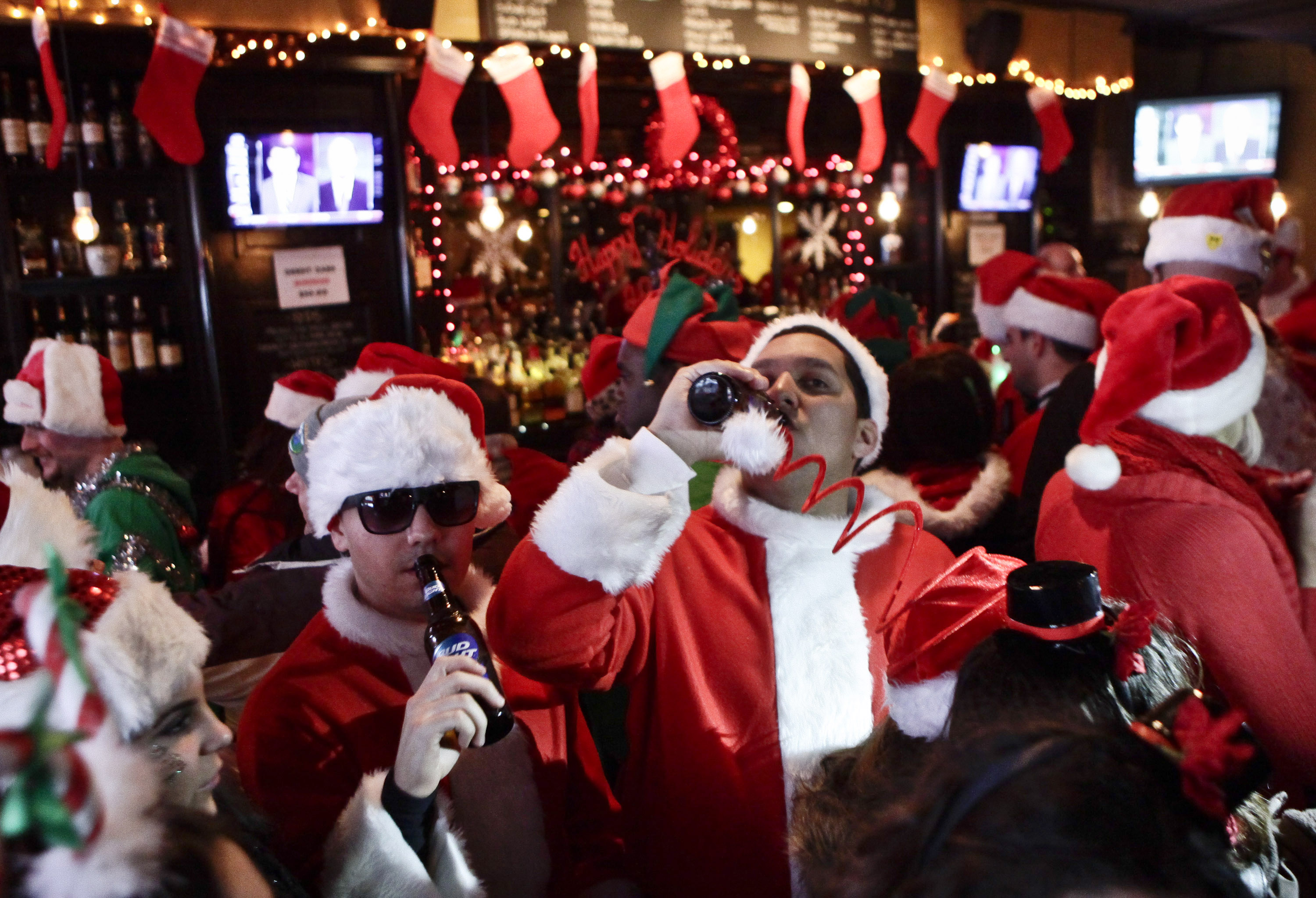 Revelers dressed as Santa Claus drink inside at a bar in the East Village neighborhood during the annual SantaCon bar crawl event on December 14, 2013 in New York City. The SantaCon annual event occurs worldwide in more than 300 cities in 44 countries. In New York some community groups have established a 'Santa Free' zone that urges bars not to serve alcoholic beverages to people participating in order to dissuade incidents of public vomiting and urination in the streets. (Photo by Kena Betancur/Getty Images) (Kena Betancur&mdash;Getty Images)