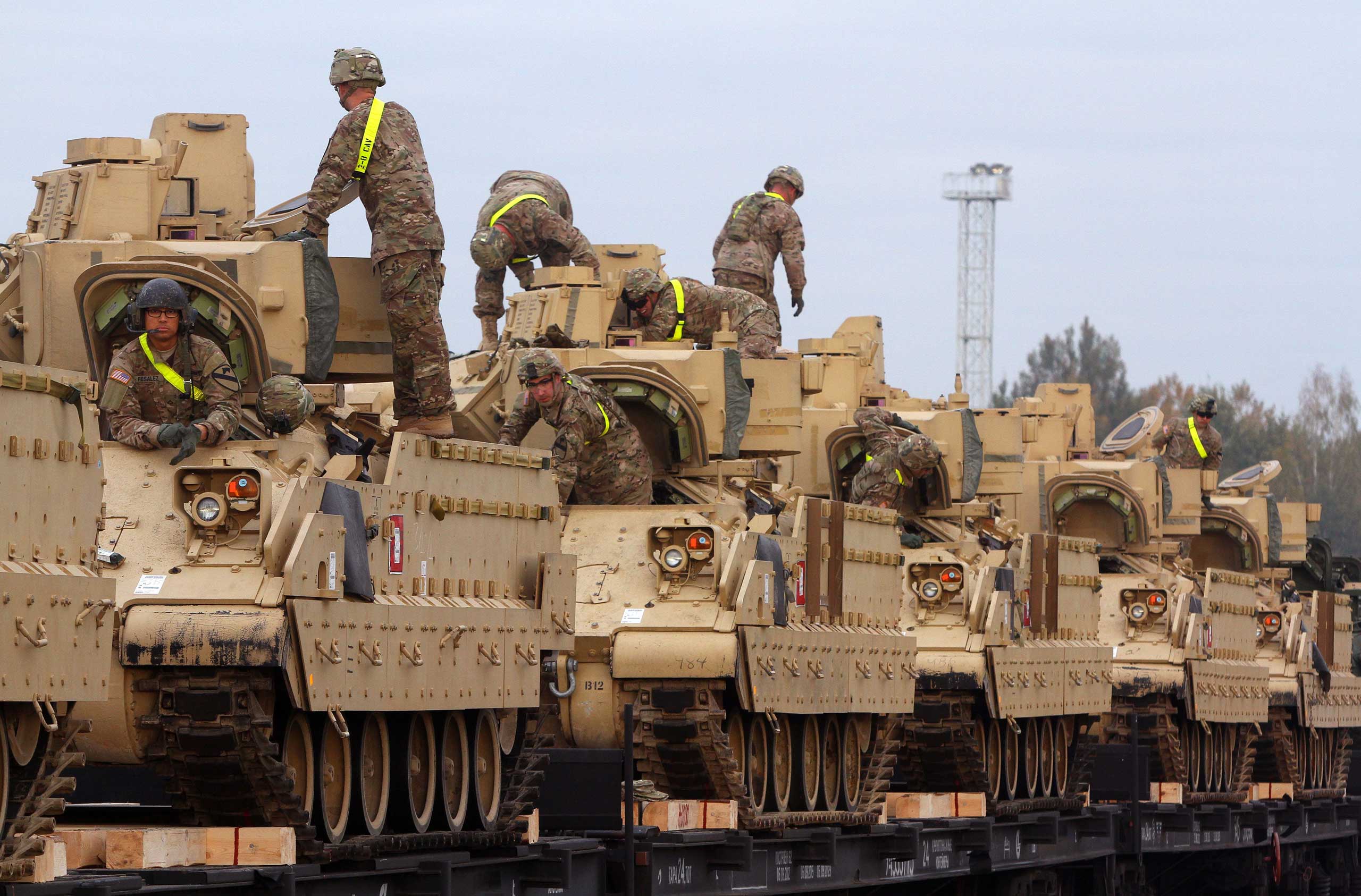 Members of the US Army 1st Brigade, 1st Cavalry Division, transport heavy combat equipment including Bradley Fighting Vehicles at the railway station near the Rukla military base in Lithuania, Oct. 4, 2014. (Petras Malukas—AFP/Getty Images)