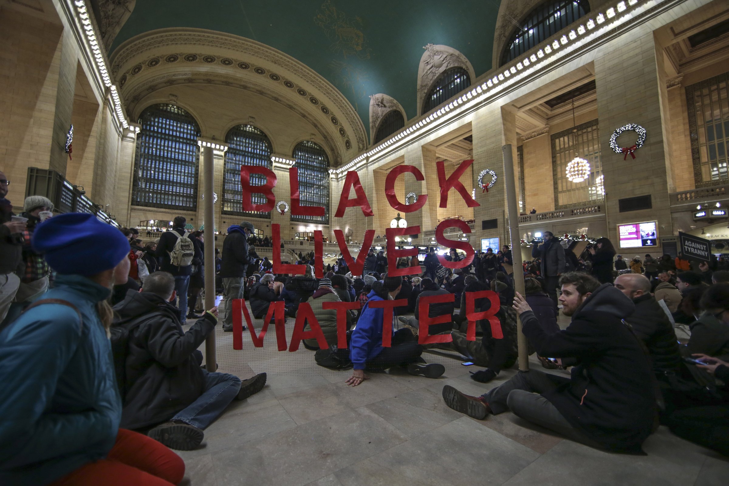 NEW YORK, NY - DECEMBER 7: Protesters hold a banner during a protest at Grand Central Terminal after a grand jury decided not to indict a police officer involved in the death of  Eric Garner in July on December 7, 2014 in New York, N.Y. Protests are being staged nationwide after grand juries investigating the deaths of Michael Brown in Ferguson, Missouri and Eric Garner in New York failed to indict the police officers involved in both incidents. (Photo by Bilgin S. Sasmaz/Anadolu Agency/Getty Images)