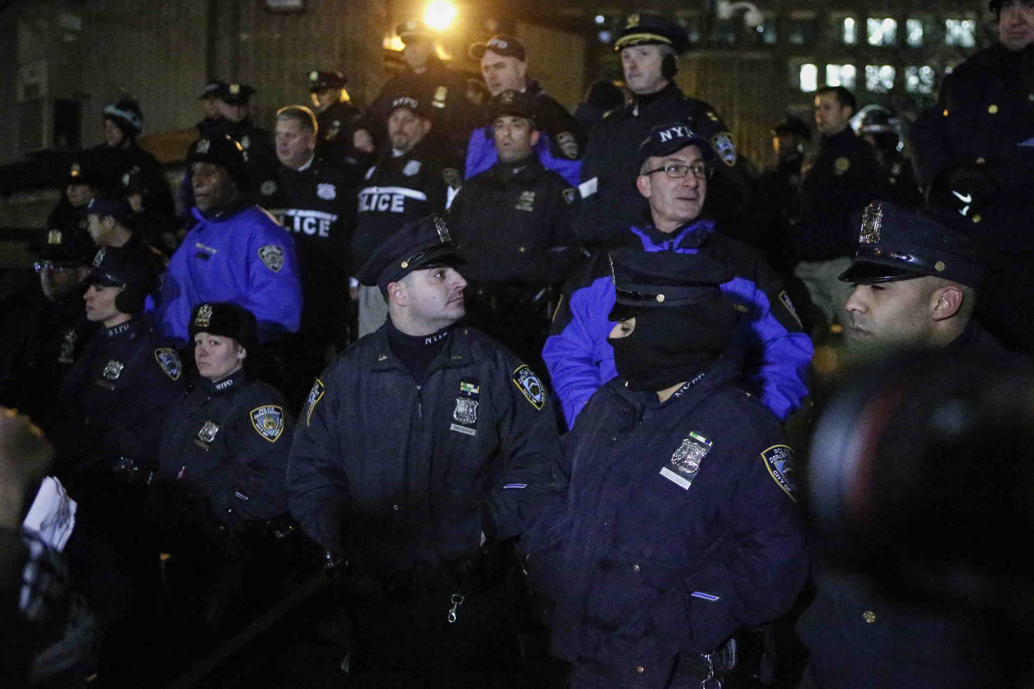 NYPD officers stand guard during the National March Against Police Violence, which was organized by National Action Network, at One Police Plaza on December 13, 2014 in New York City. (Kena Betancur—Getty Images)