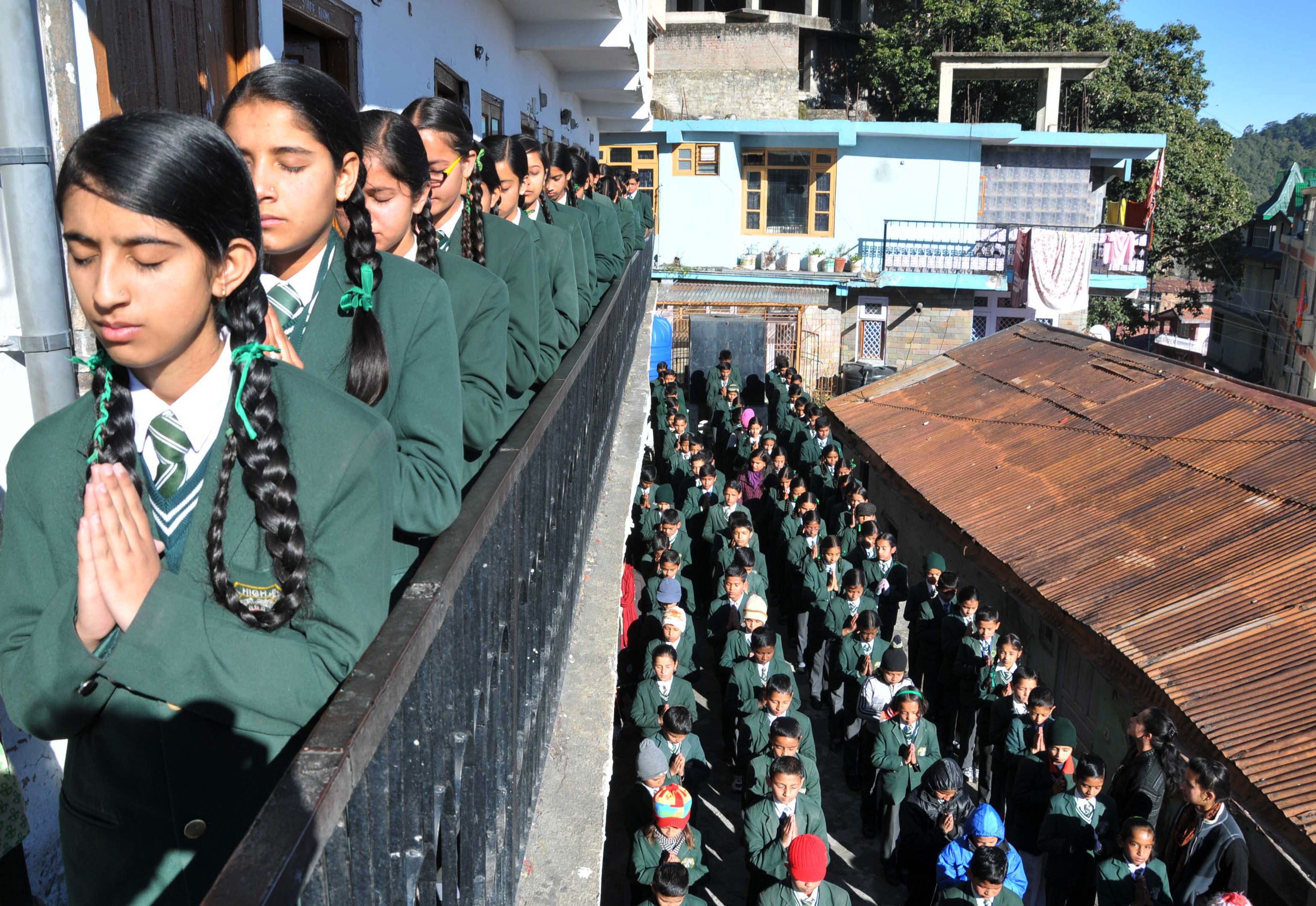 Schoolchildren pray during morning assembly at their school in Shimla, India, on Dec. 17, 2014, as they pay tribute to slain students and staff after an attack on an army school in Peshawar, Pakistan (STRDEL—AFP/Getty Images)