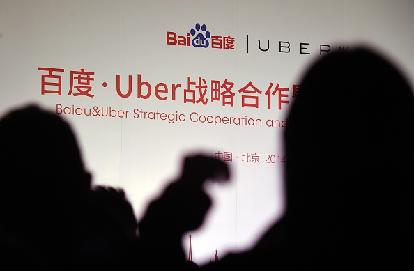 Journalists wait for the start of a signing ceremony between Uber and Baidu at the Baidu headquarters in Beijing on Dec. 17, 2014 (Greg Baker—AFP/Getty Images)
