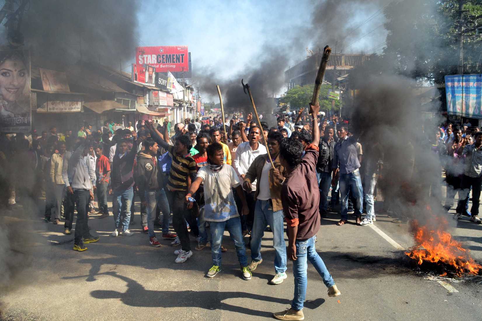 Activists of the Assam Tea Tribes Student Association (ATTSA) shout slogans as they block the road with burning tyres during a protest against attacks on villagers by militants in four different locations, at Biswanath Chariali in the Sonitpur district of northeastern Assam state on December 24, 2014 (STRDEL—AFP/Getty)