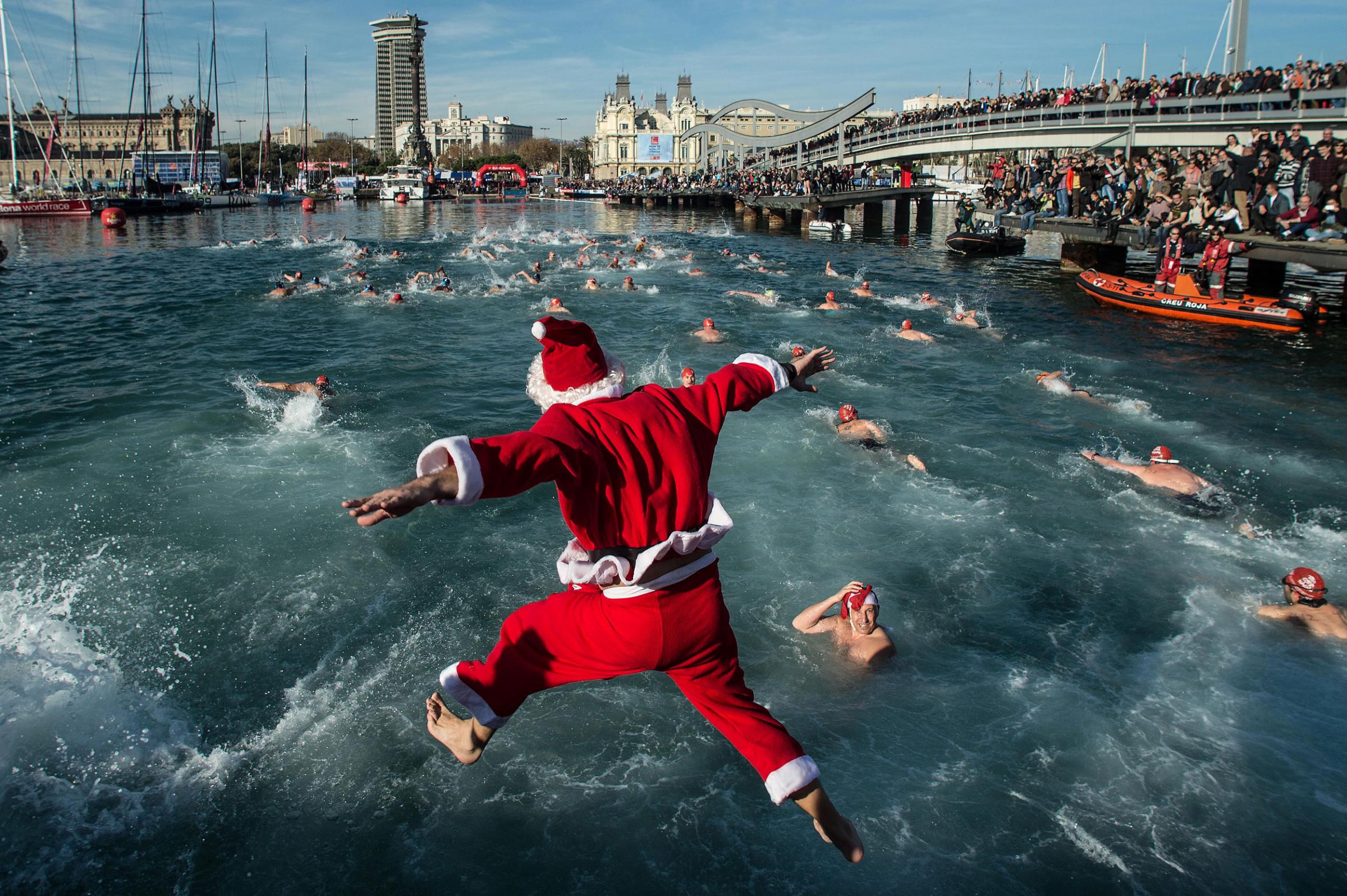 A competitor in Christmas fancy dress jumps into the sea during the 105th Barcelona Traditional Christmas Swimming Cup at the Old Harbour of Barcelona on Dec. 25, 2014 in Barcelona, Spain. The Copa Nadal is organised by the Barcelona Swimming Club and involves competitors swimming across some 200 metres of water in the harbour.
