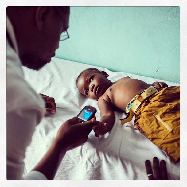 A doctor at work. Ifakara, Tanzania. What I really like the most in this photo is the mother's silent hand in the frame. What will we do without mothers? 
                              Photo by Nana Kofi Acquah @africashowboy (Copyright: 2014).