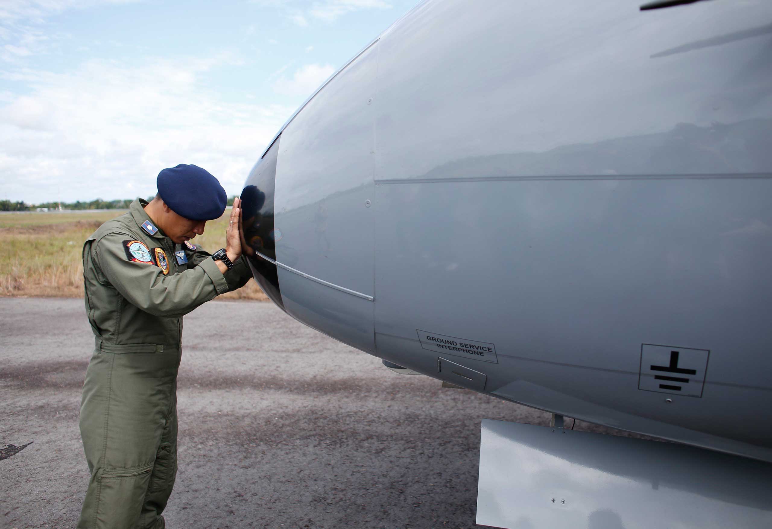 A crew member of an Indonesian Maritime Surveillance plane says a prayer before a search mission to look for AirAsia's Flight QZ8501 in Pangkal Pinang, Bangka Island, Indonesia on Dec. 30, 2014.