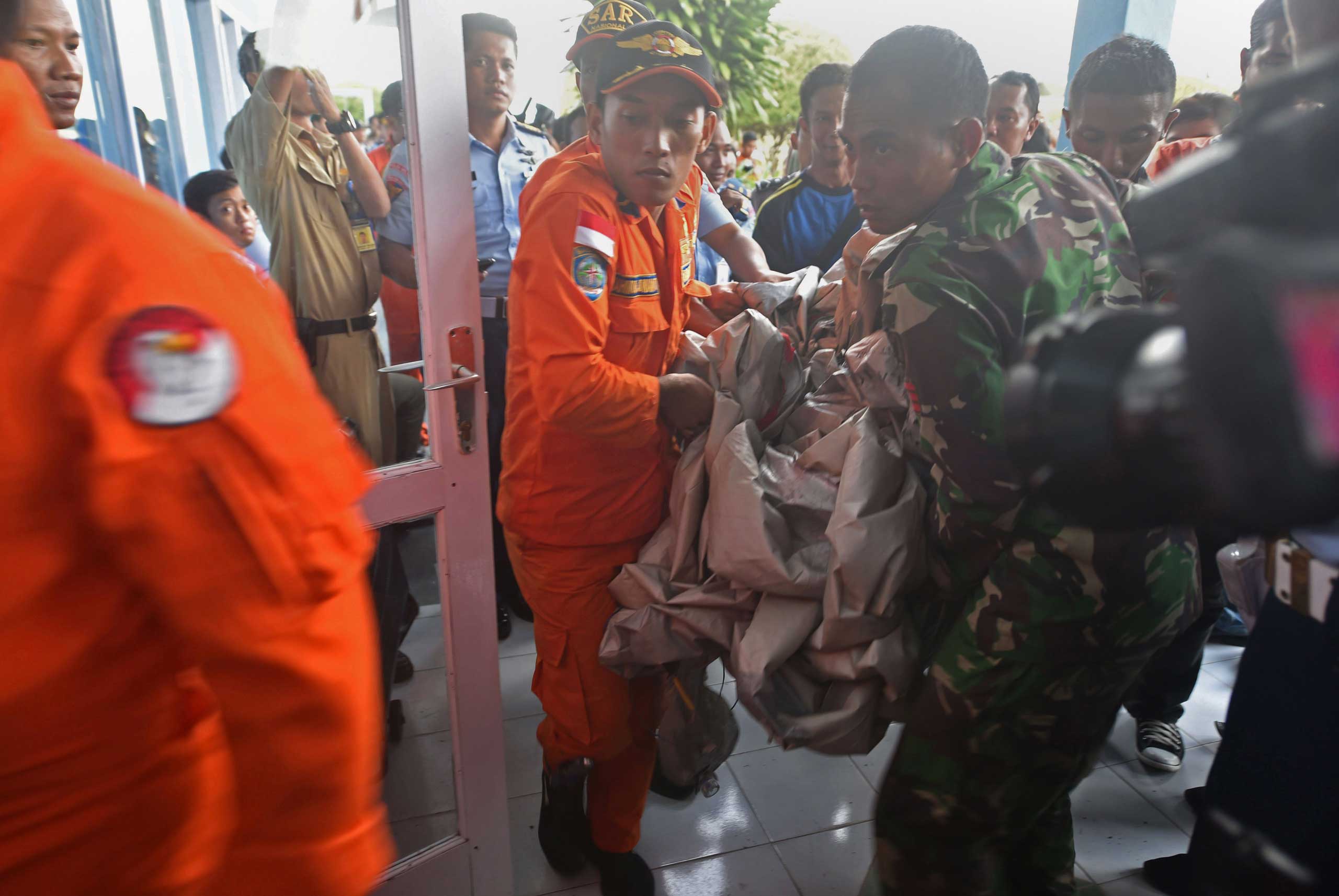Members of the Indonesian air force carry items retrieved from the Java sea during search and rescue operations for the missing AirAsia flight QZ8501, in Pangkalan Bun, Indonesia on Dec. 30, 2014.